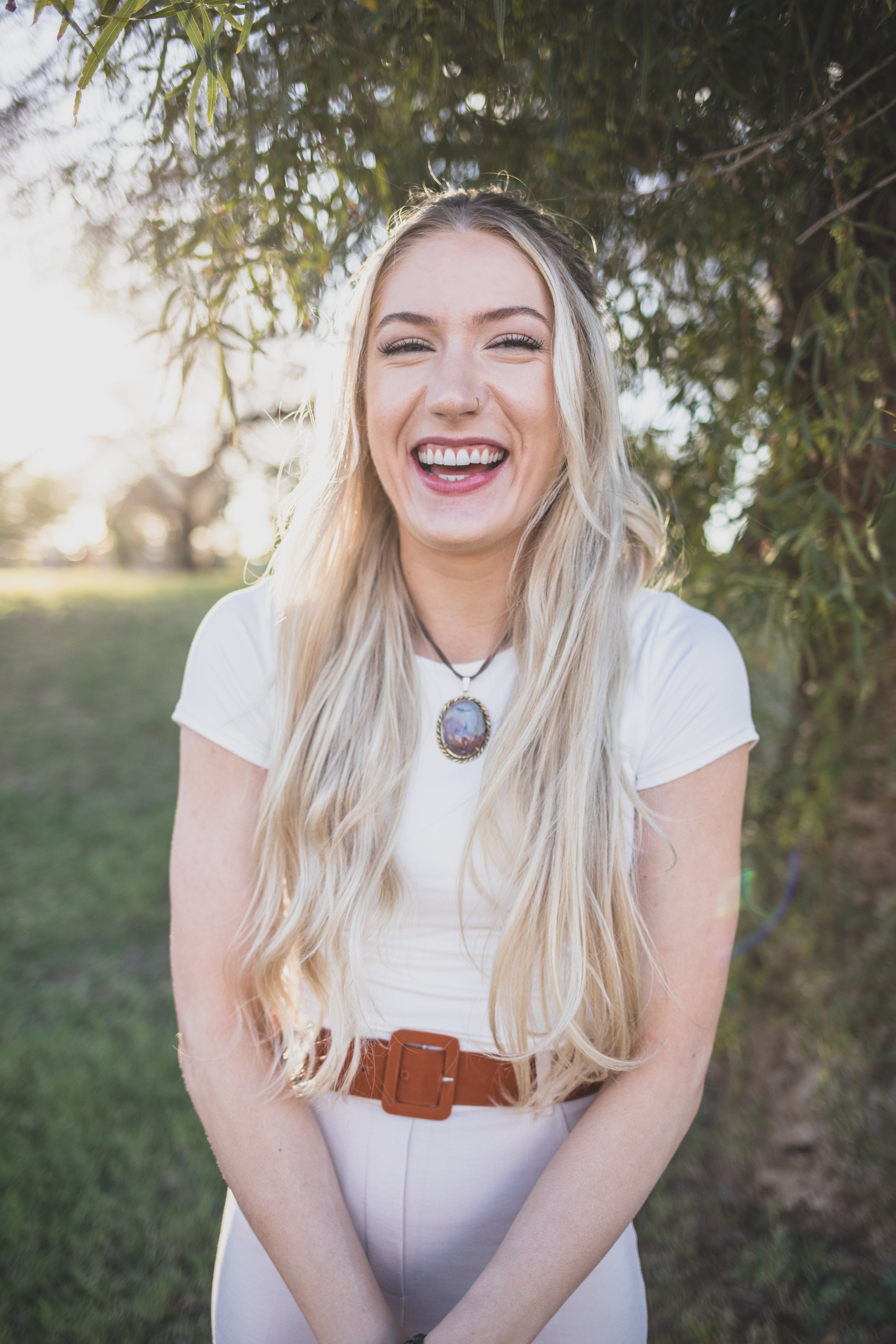 Woman laughs in front of natural backdrop for professional headshots by Scottsdale based Corporate Branding Photographer, Jennifer Lind Schutsky in Arizona.