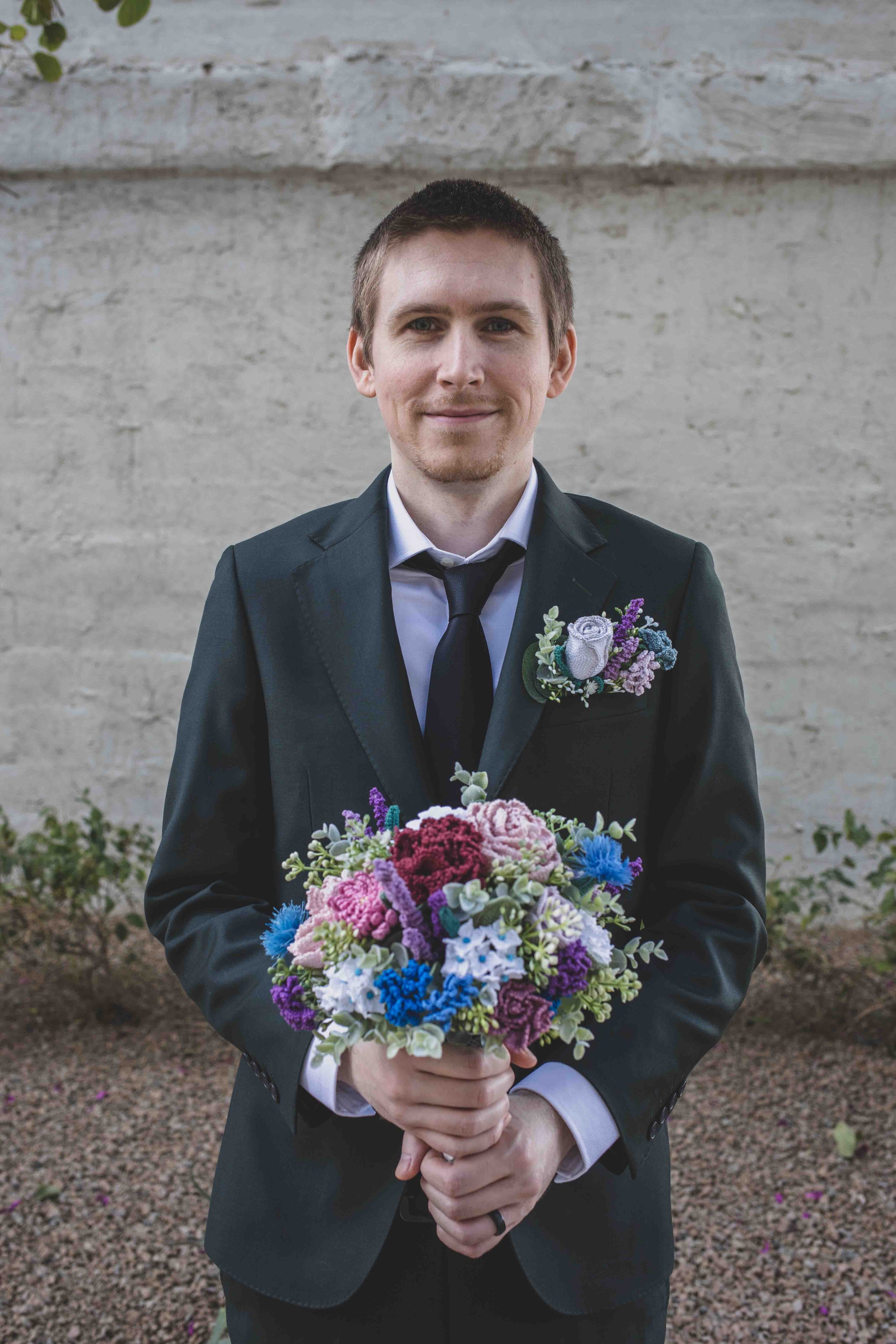 Groom holding the bride's bouquet for his wedding day by Gilbert, Arizona Wedding Photographer Jennifer Lind Schutsky.