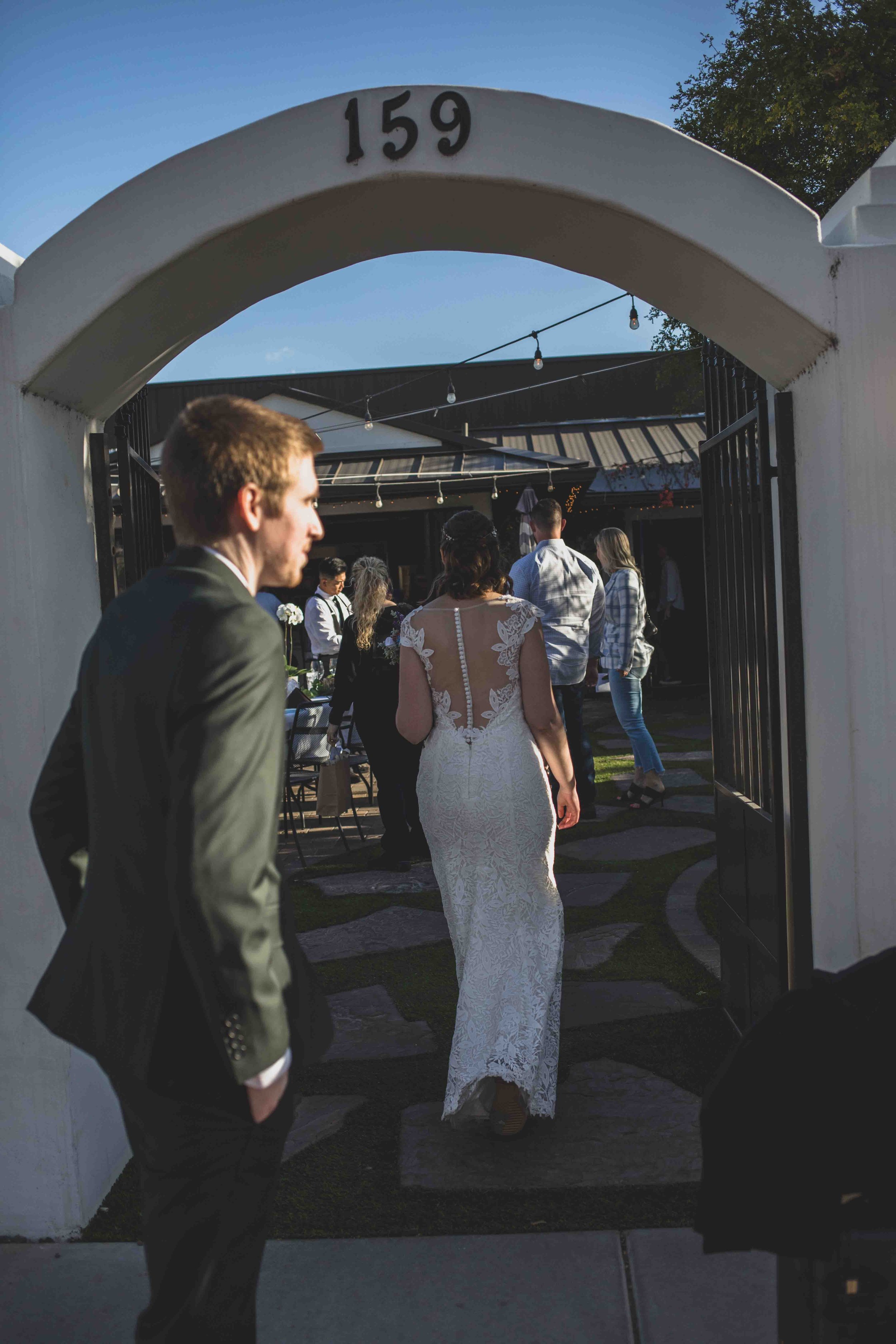 Bride and Groom walk in to their Wedding Reception at Hidden House by Gilbert, Arizona Wedding Photographer Jennifer Lind Schutsky.