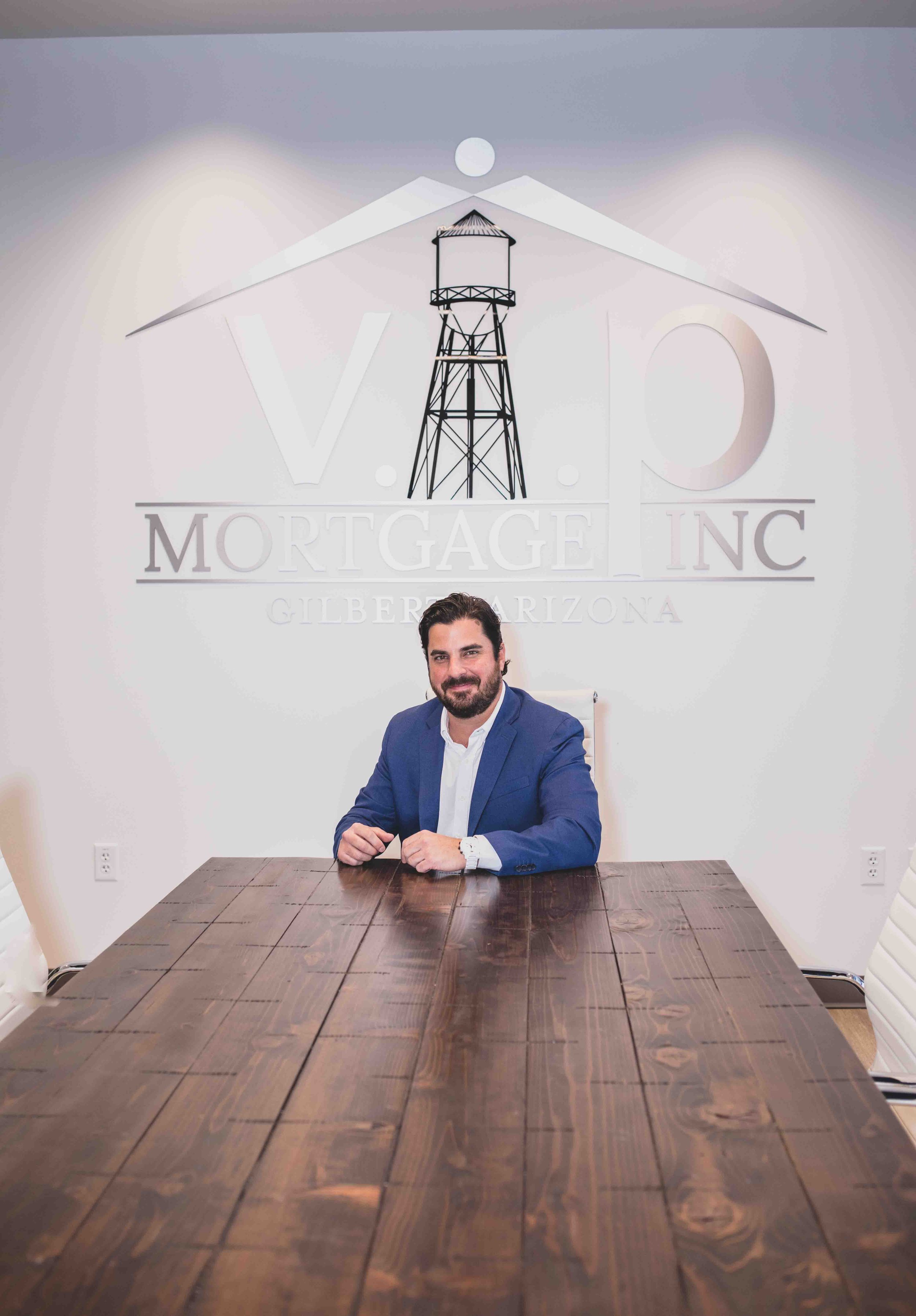 Man poses in VIP Mortgage office suites for professional headshots by best branding photographer in Phoenix, Arizona; Jennifer Lind Schutsky.