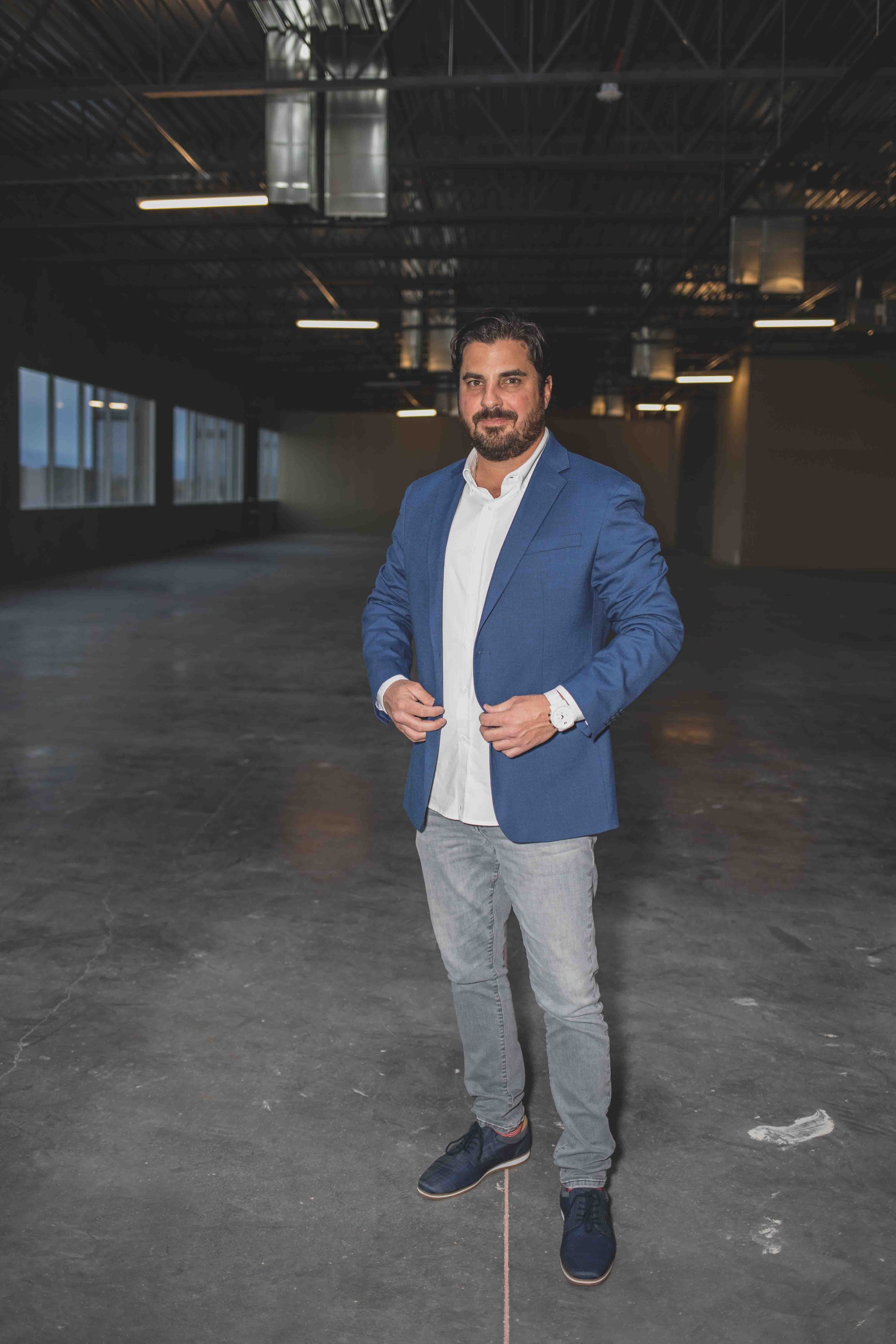 Man poses in vacant office construction site for professional headshots by best branding photographer in Phoenix, Arizona; Jennifer Lind Schutsky.