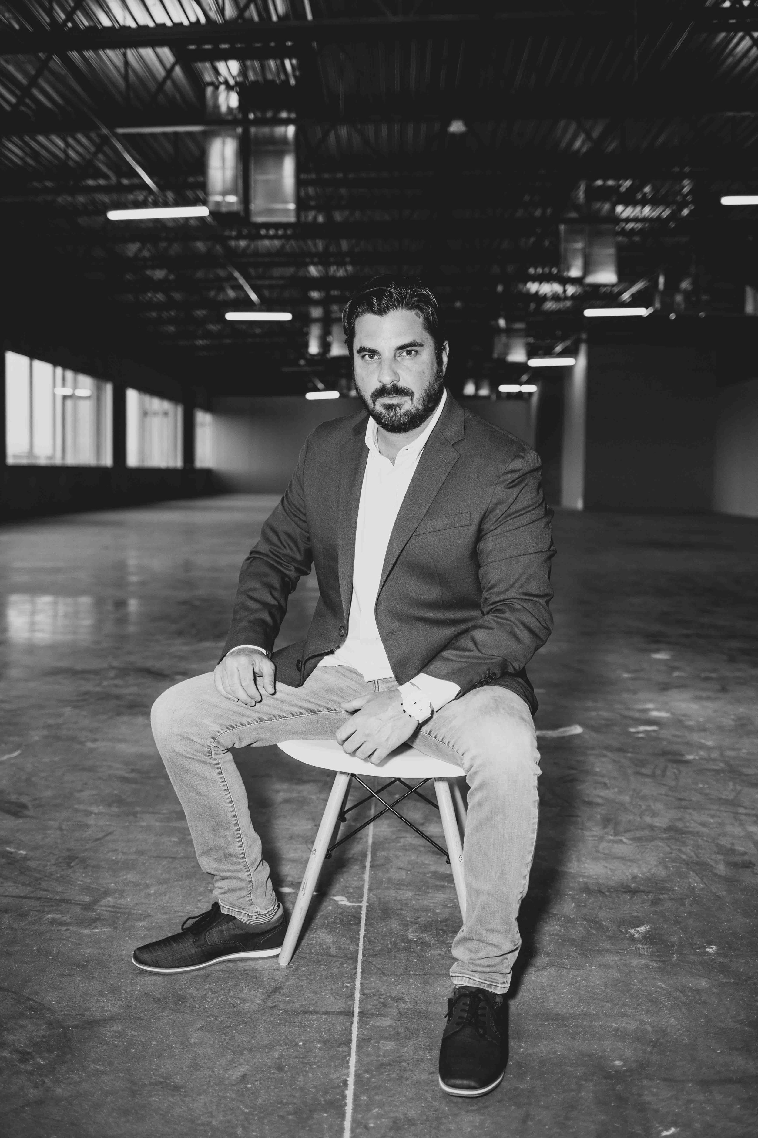 Man poses in vacant office construction site for professional headshots by best branding photographer in Phoenix, Arizona; Jennifer Lind Schutsky.