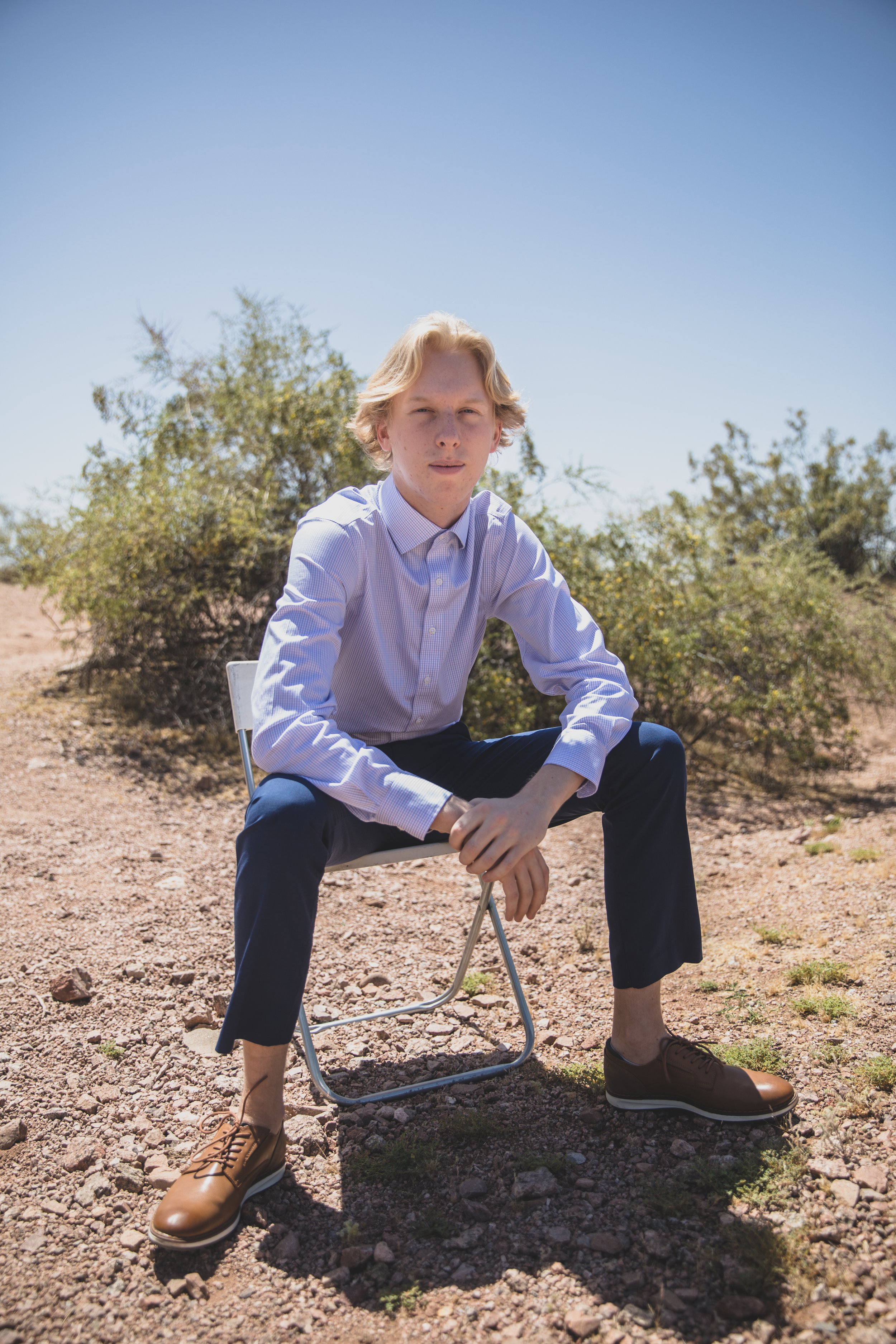 High School Senior poses for his senior photos at midday desert senior photos session with Phoenix Senior Photos Photographer, Jennifer Lind Schutsky.