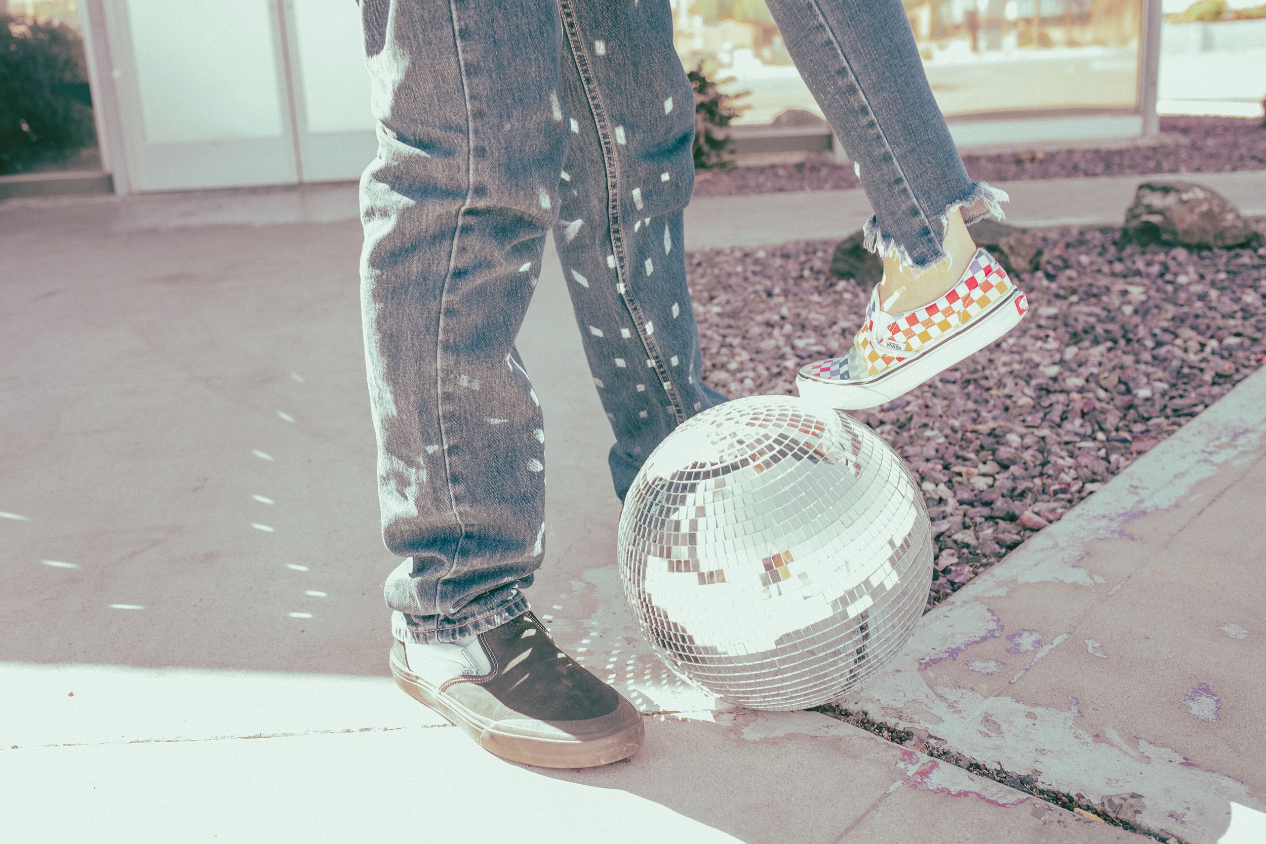 Couple poses for their retro bike and skateboard photoshoot with a disco ball at Bowlero in Phoenix, Arizona by the most creative family photographer in Phoenix; Jennifer Lind Schutsky.