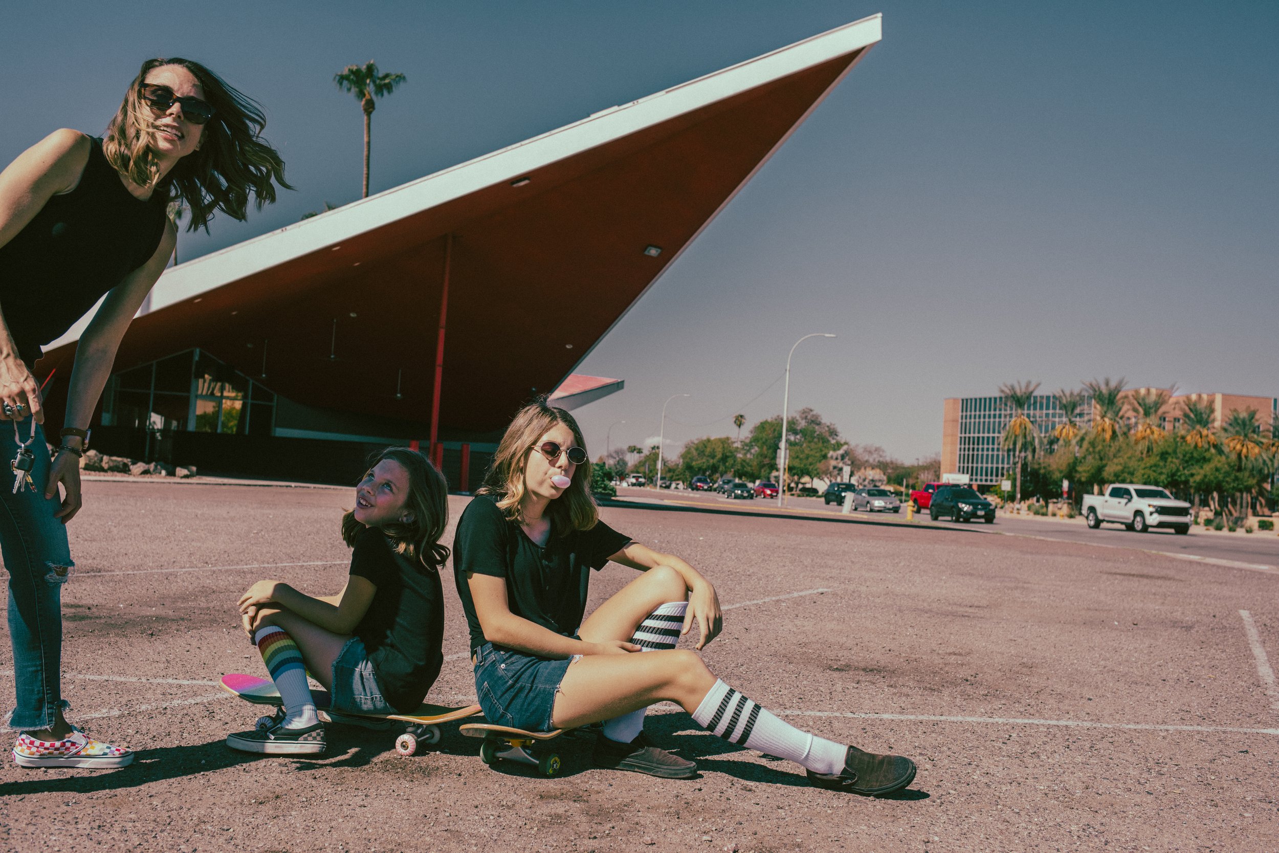 Family poses for their retro bike and skateboard photoshoot at Bowlero in Phoenix, Arizona by creative family photographer; Jennifer Lind Schutsky.