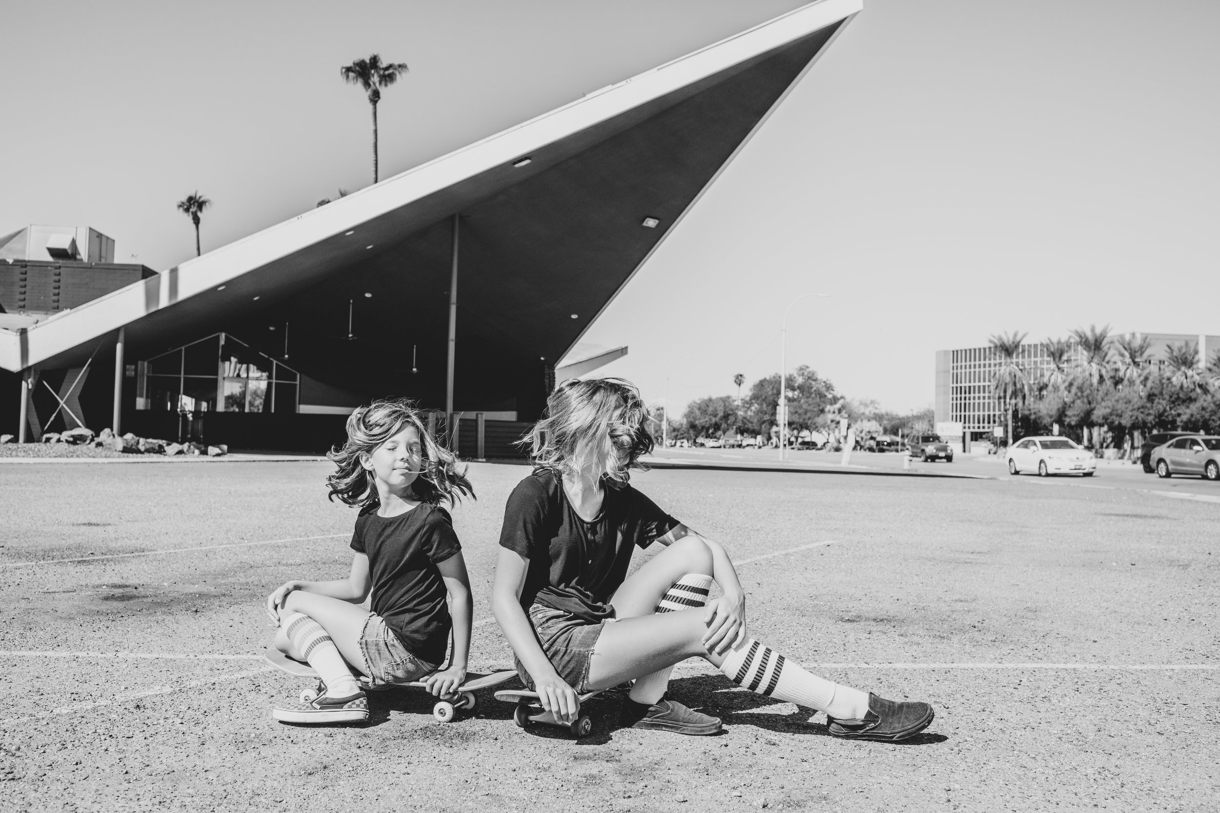 Kids pose for their retro bike and skateboard photoshoot at Bowlero in Phoenix, Arizona by creative family photographer; Jennifer Lind Schutsky.