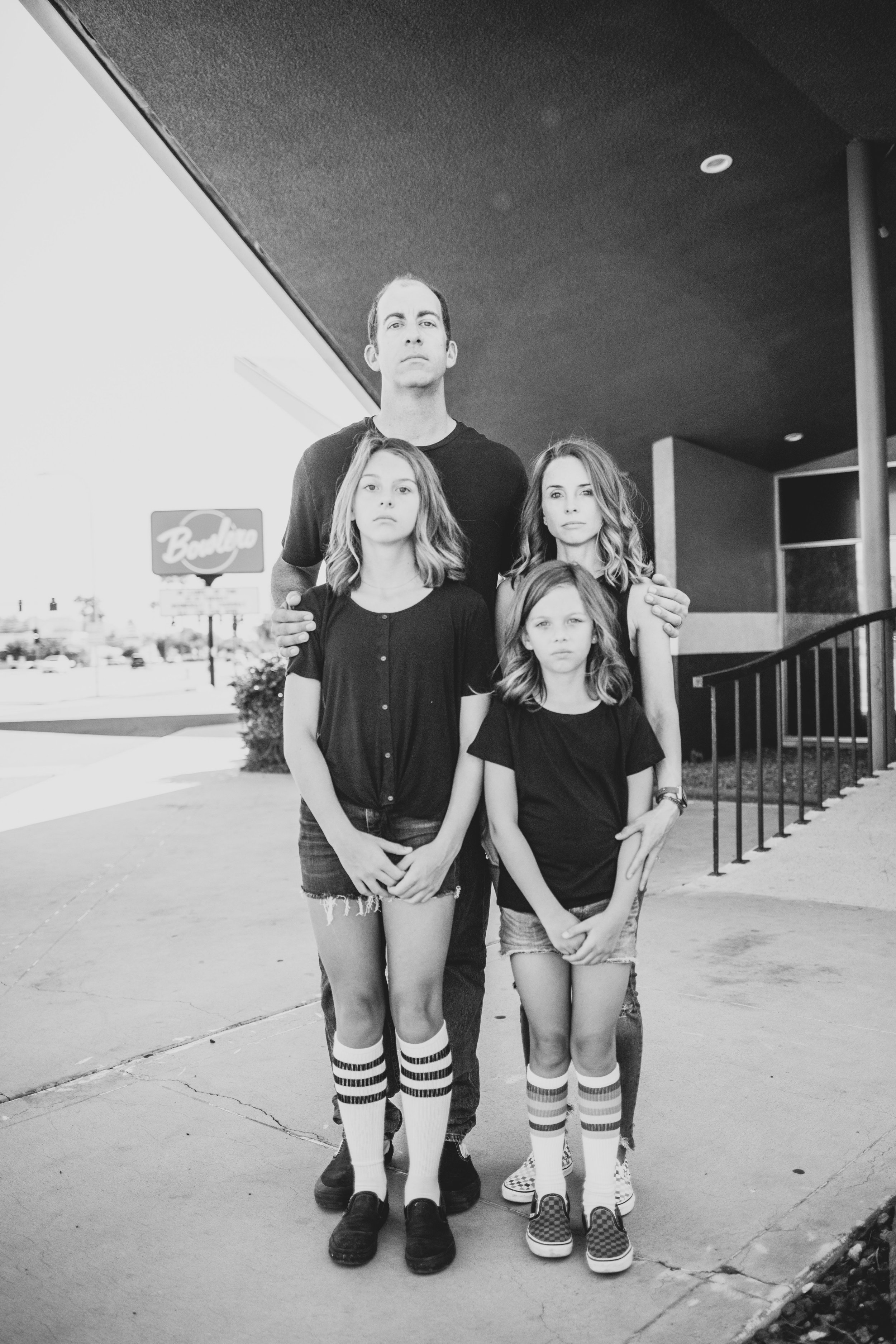 Family poses for retro bike and skateboard photoshoot at Bowlero in Phoenix, Arizona by creative family photographer; Jennifer Lind Schutsky.