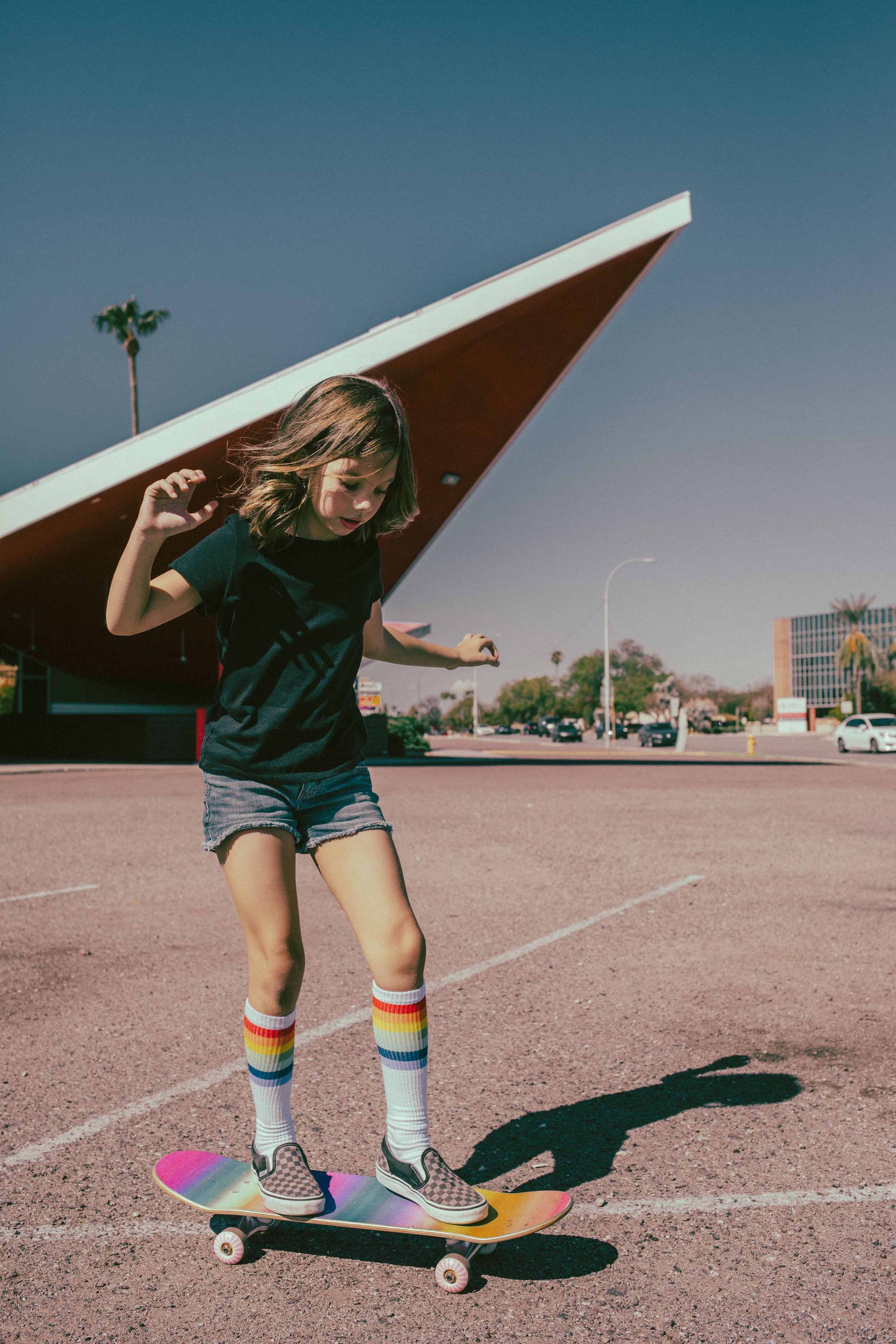 Kid poses for retro bike and skateboard photoshoot at Bowlero in Phoenix, Arizona by creative family photographer; Jennifer Lind Schutsky.