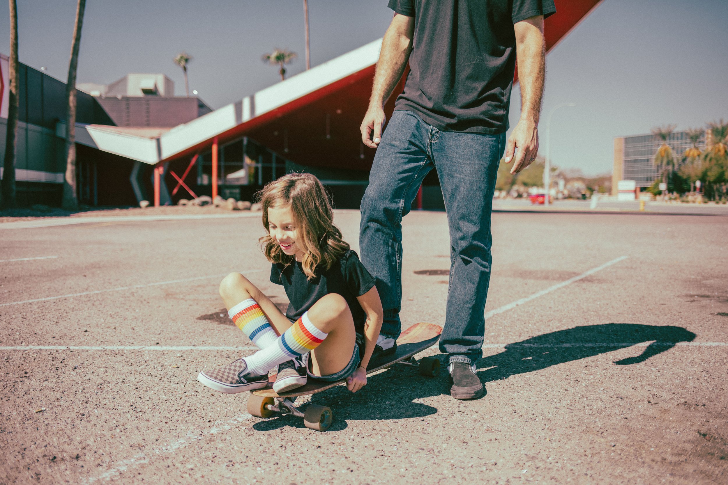 Kid poses for retro bike and skateboard photoshoot at Bowlero in Phoenix, Arizona by creative family photographer; Jennifer Lind Schutsky.