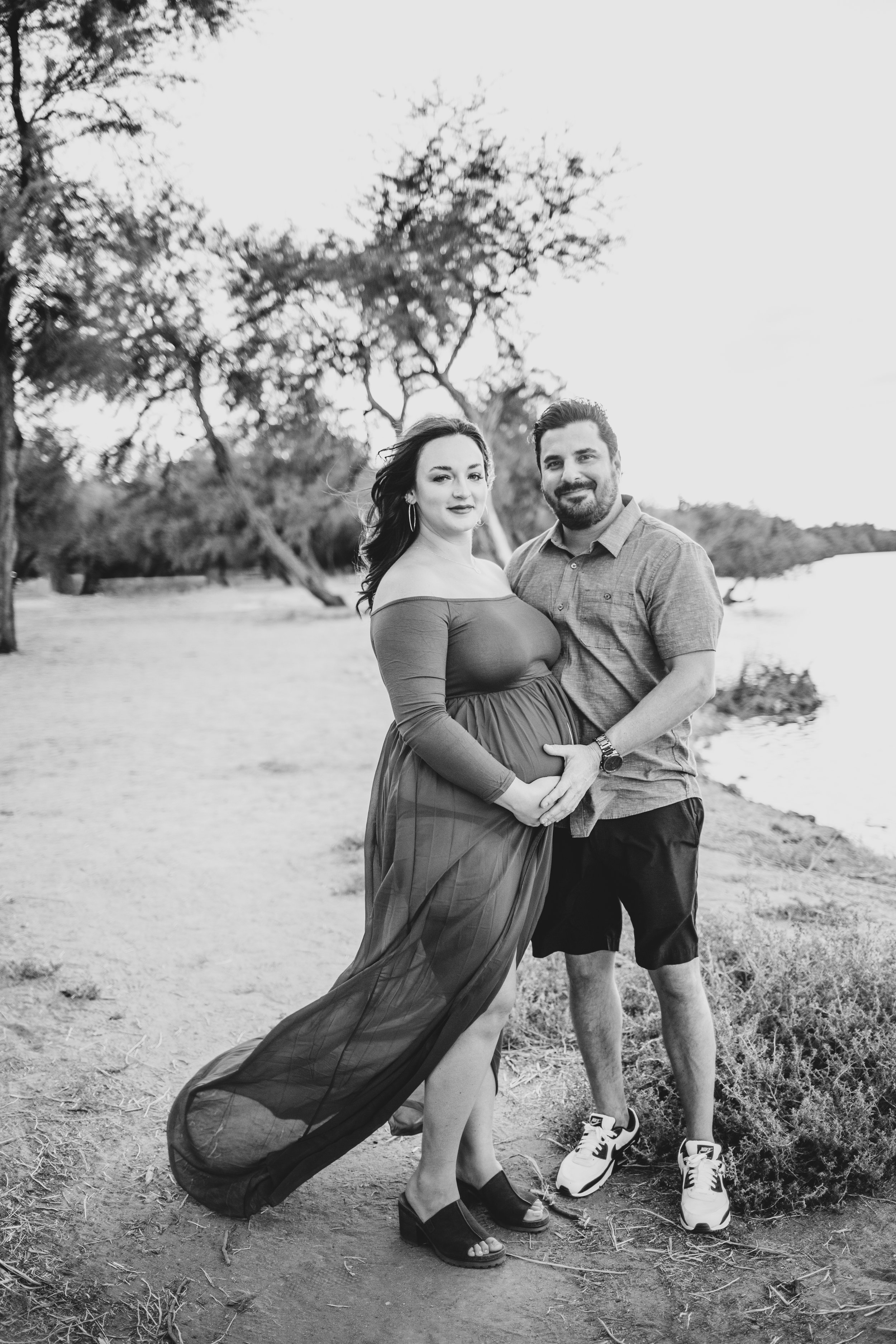 Parents poses for maternity photos in the water at the Salt River by timeless Phoenix maternity photographer; Jennifer Lind Schutsky.
