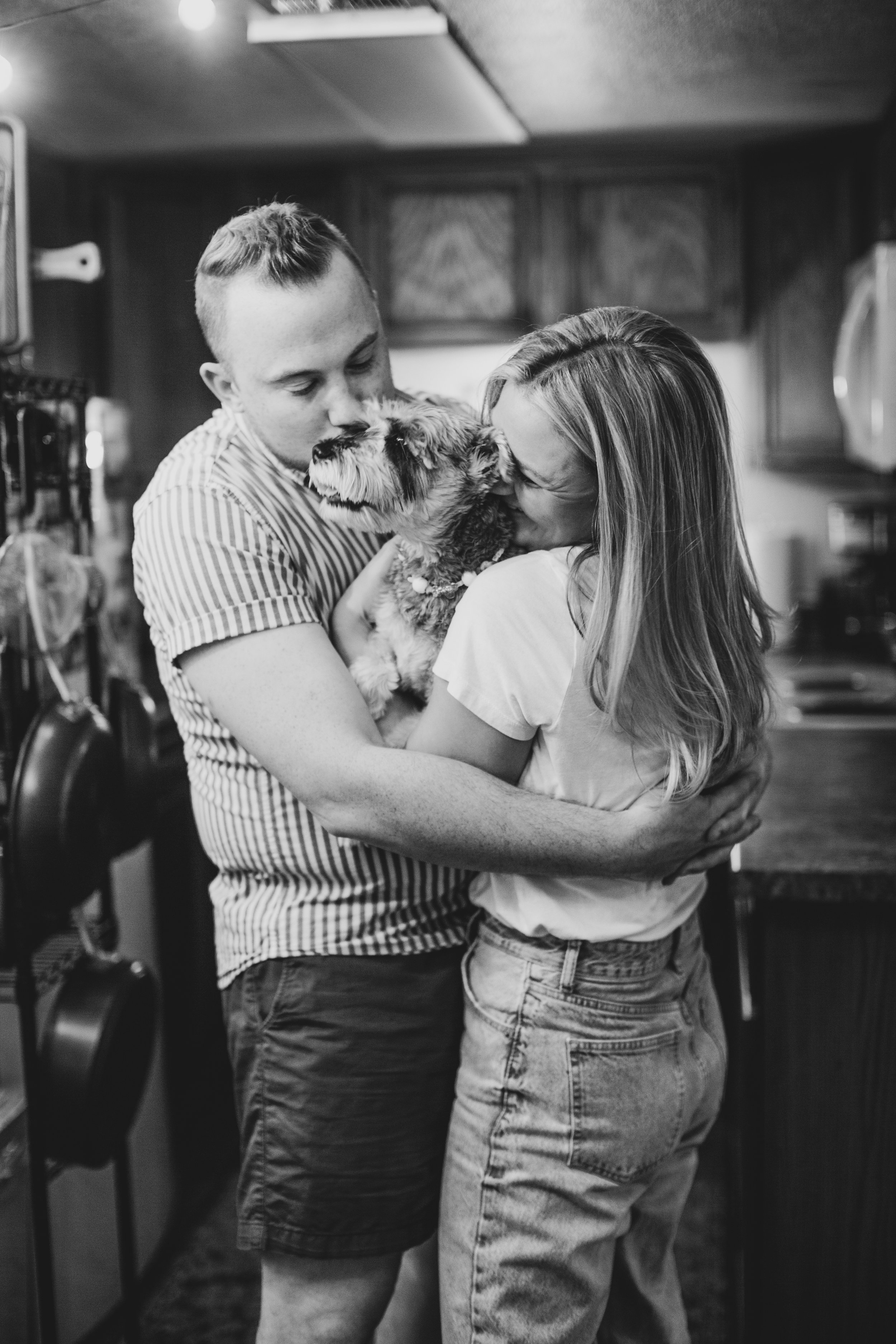 Newly engaged couple dance with their dog in the kitchen during their In-Home Engagement Session with Phoenix based intimate engagement photographer Jennifer Lind Schutsky. 