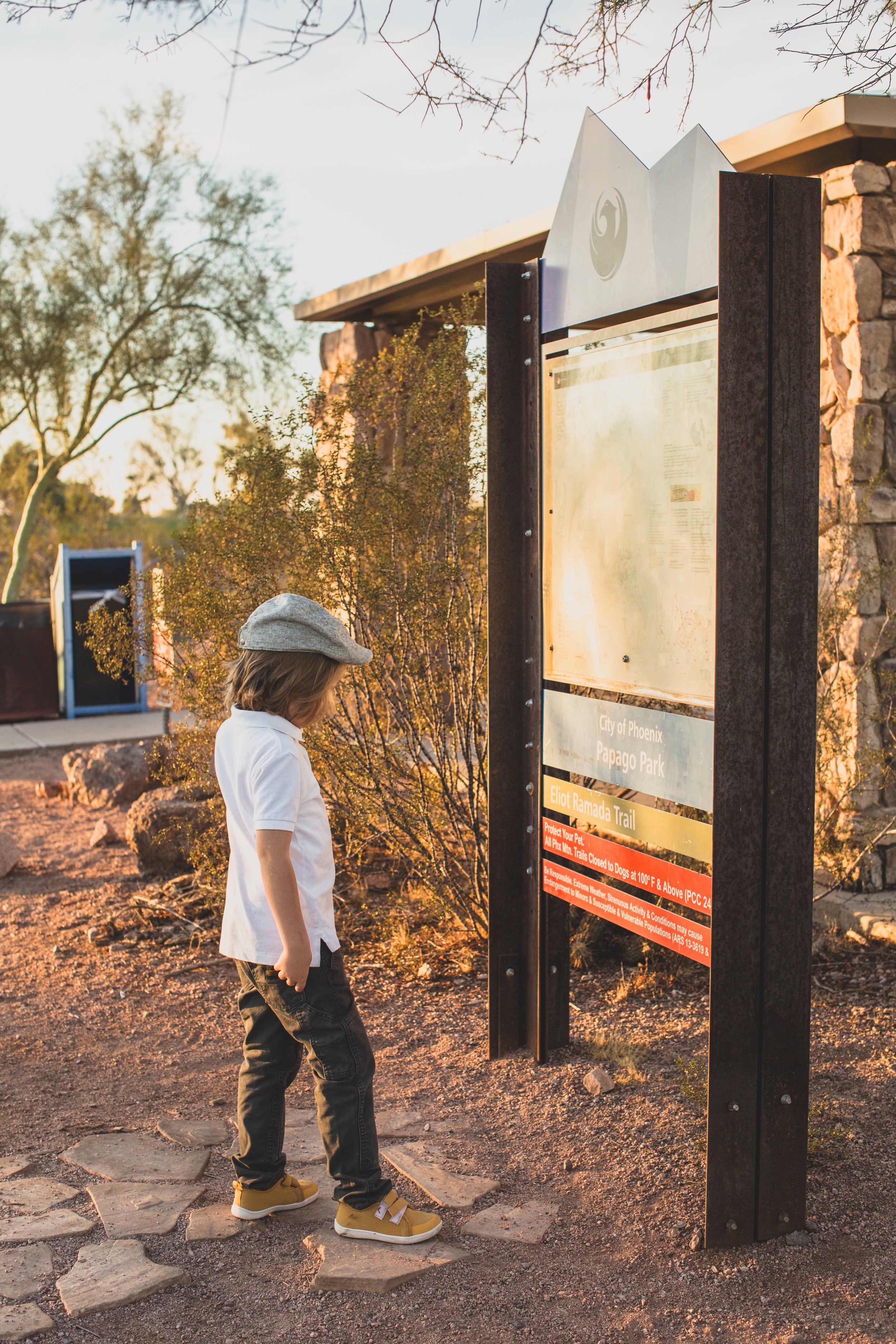 Stylish young kid poses for his family desert photo session near Papago Park in Tempe, Arizona by Phoenix based family photographer Jennifer Lind Schutsky. 