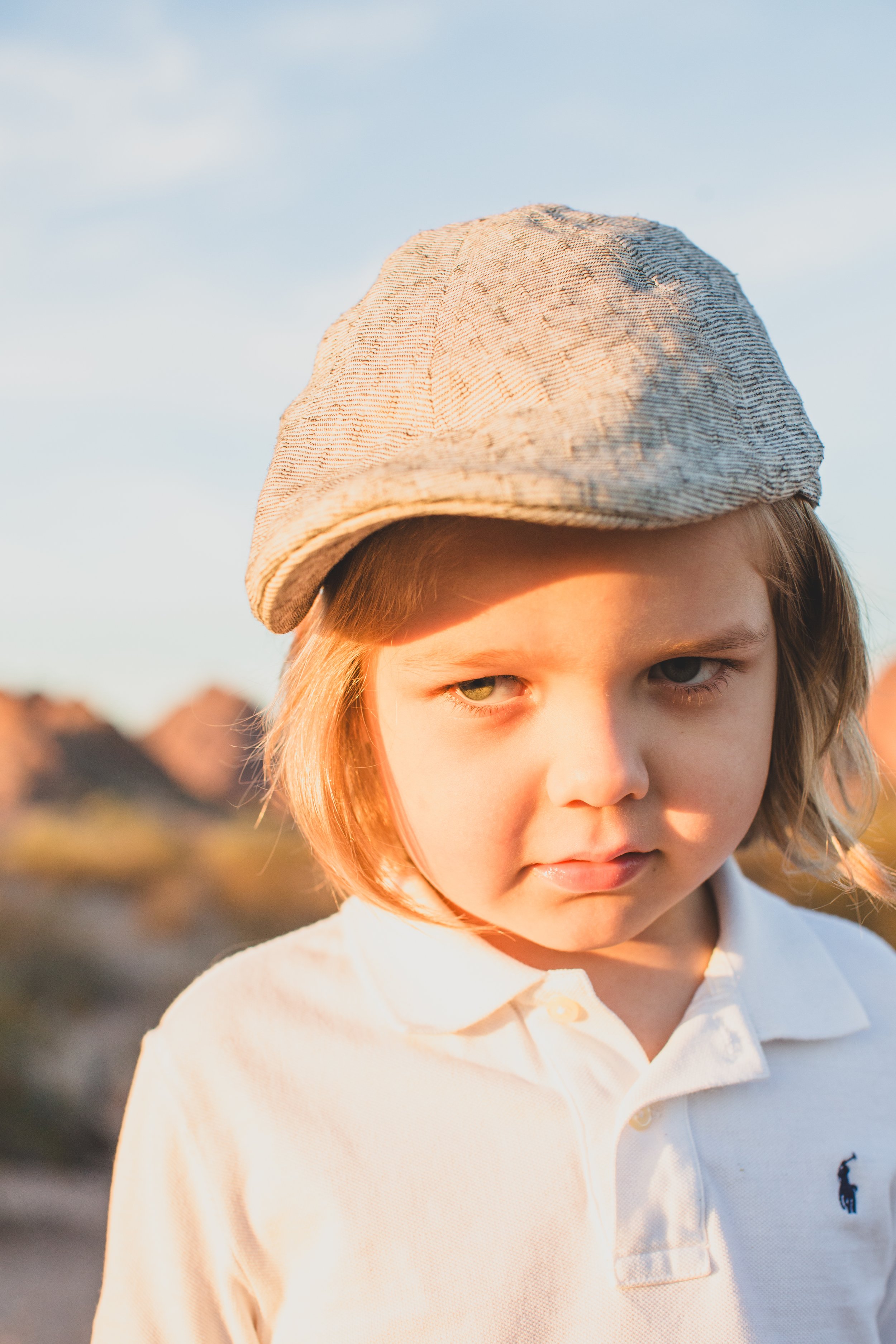 Stylish young kid poses for his family desert photo session near Papago Park in Tempe, Arizona by Phoenix based family photographer Jennifer Lind Schutsky. 