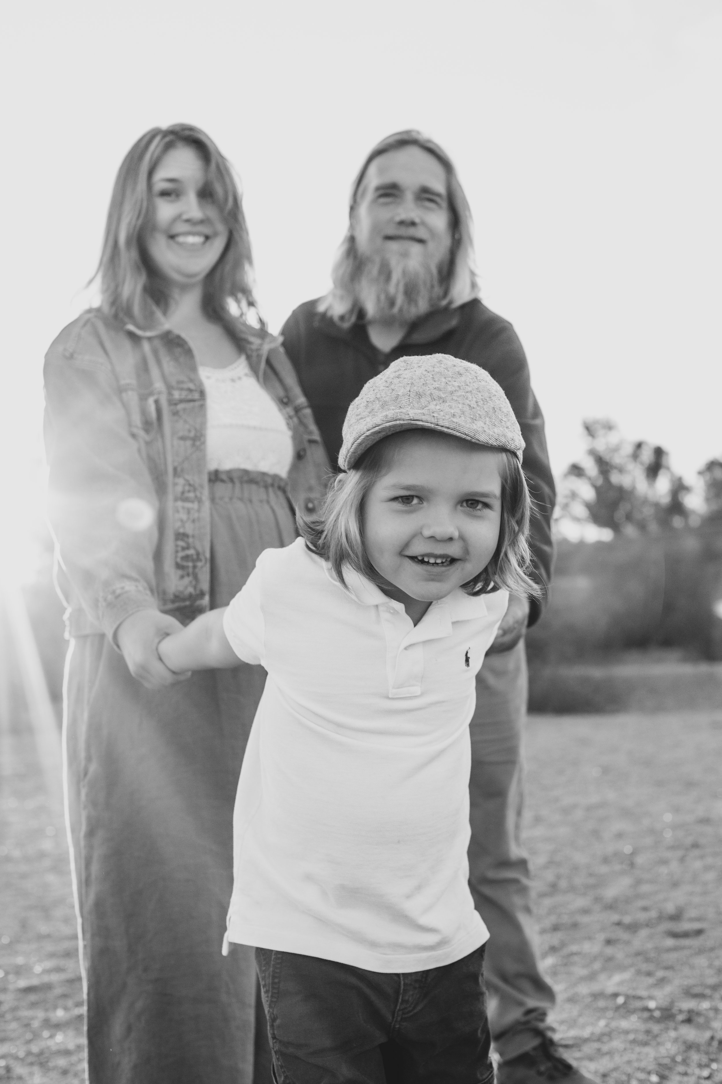 Casual dressed family poses during family desert photo session near Papago Park in Tempe, Arizona by Phoenix based family photographer Jennifer Lind Schutsky. 