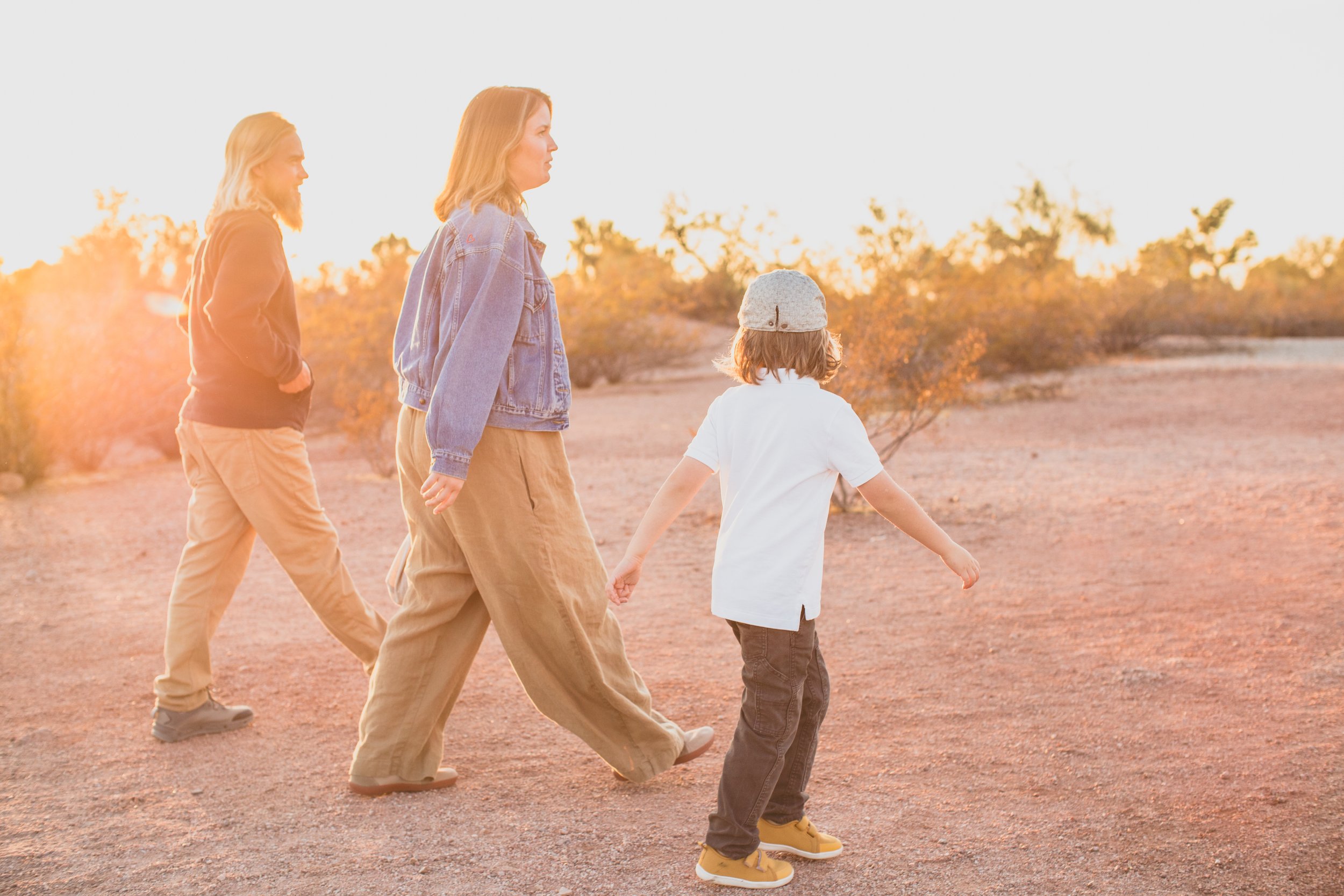 Casual dressed family poses during family desert photo session near Papago Park in Tempe, Arizona by Phoenix based family photographer Jennifer Lind Schutsky. 