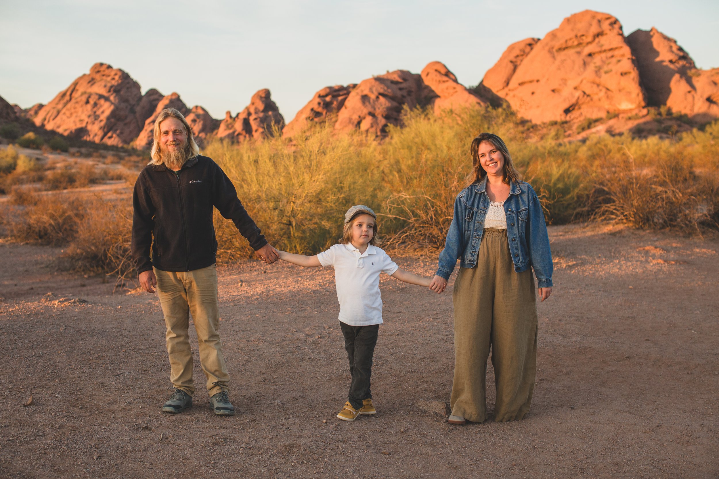 Casual dressed family poses during family desert photo session near Papago Park in Tempe, Arizona by Phoenix based family photographer Jennifer Lind Schutsky. 