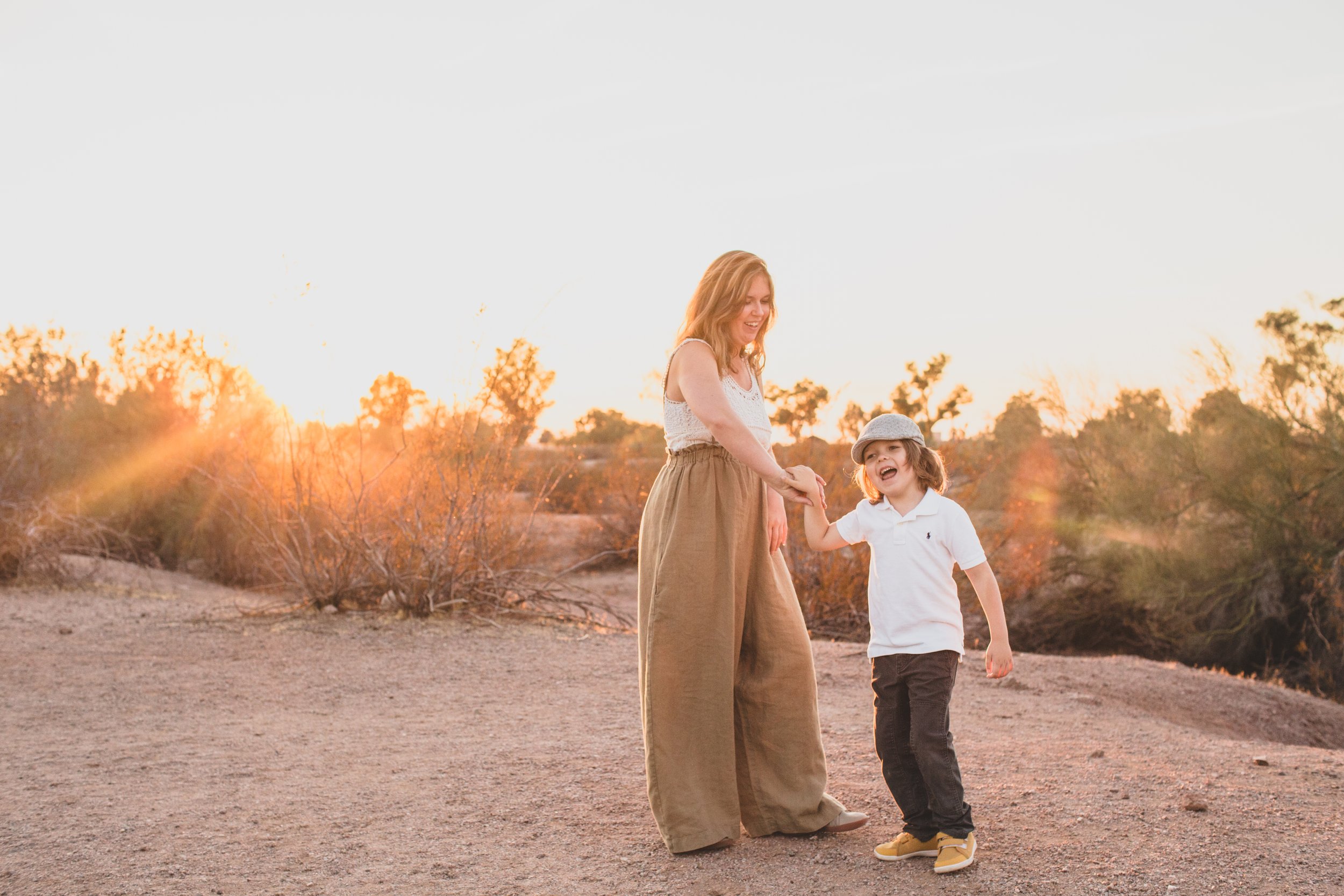 Mother and son dance together during family desert photo session near Papago Park in Tempe, Arizona by Phoenix based family photographer Jennifer Lind Schutsky. 