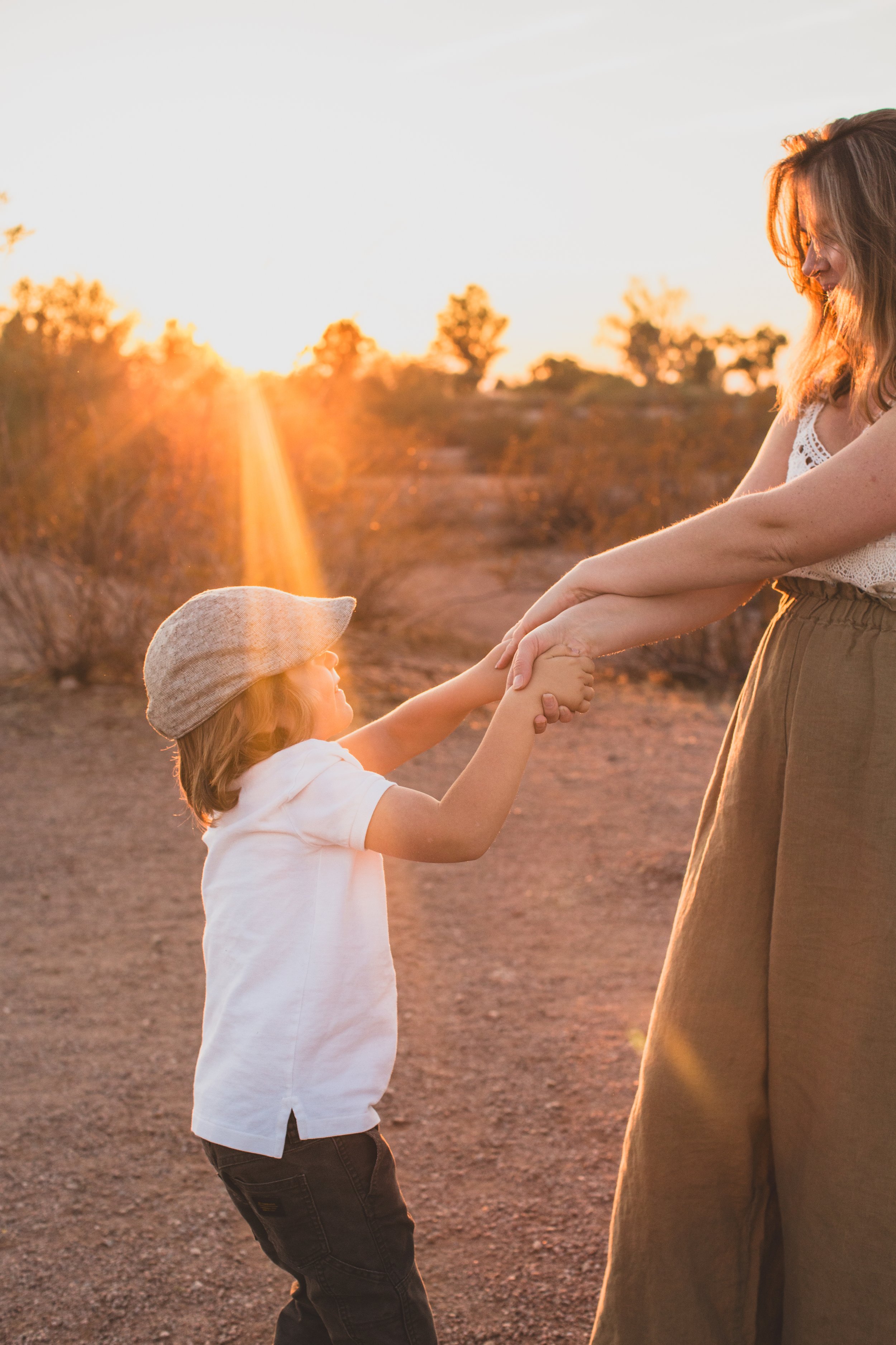 Mother and son dance together during family desert photo session near Papago Park in Tempe, Arizona by Phoenix based family photographer Jennifer Lind Schutsky. 