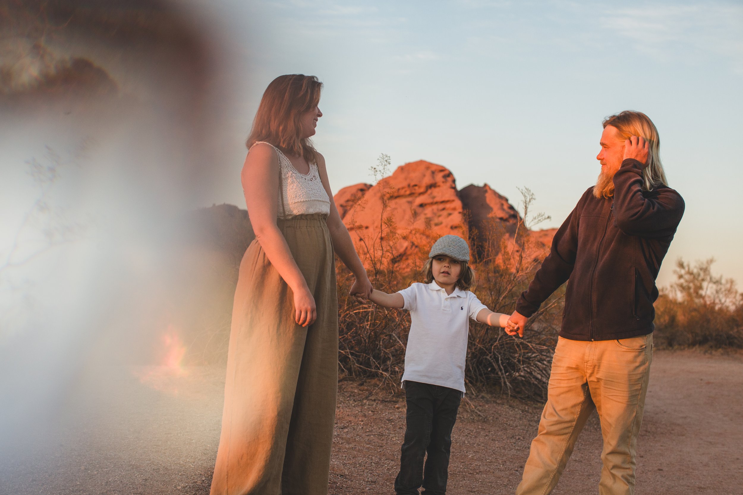 Mom and dad hug during family desert photo session near Papago Park in Tempe, Arizona by Phoenix based family photographer Jennifer Lind Schutsky. 