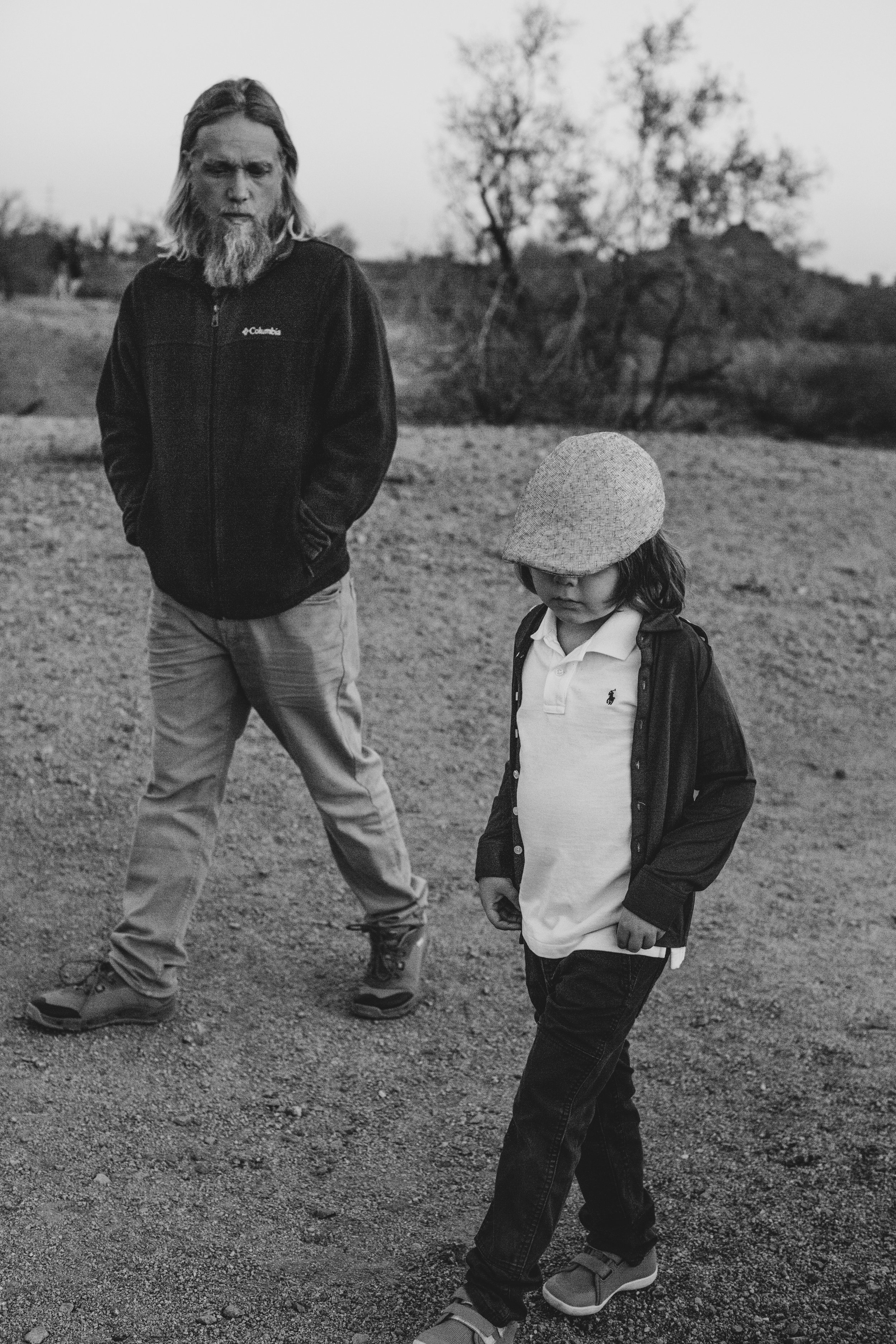 Stylish young kid walks with dad while playing at his family desert photo session near Papago Park in Tempe, Arizona by Phoenix based family photographer Jennifer Lind Schutsky. 