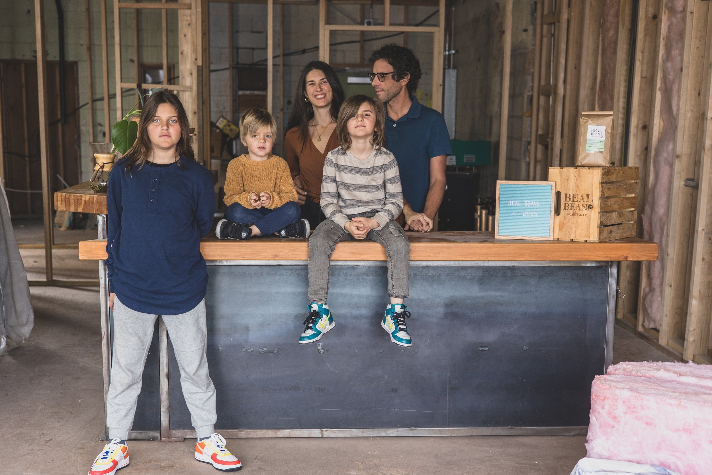 Family poses for their unique photo session in the unfinished Beal Beans’ new coffee shop coming to Sunnyslope, AZ by Arizona family photographer, Jennifer Lind Schutsky. 