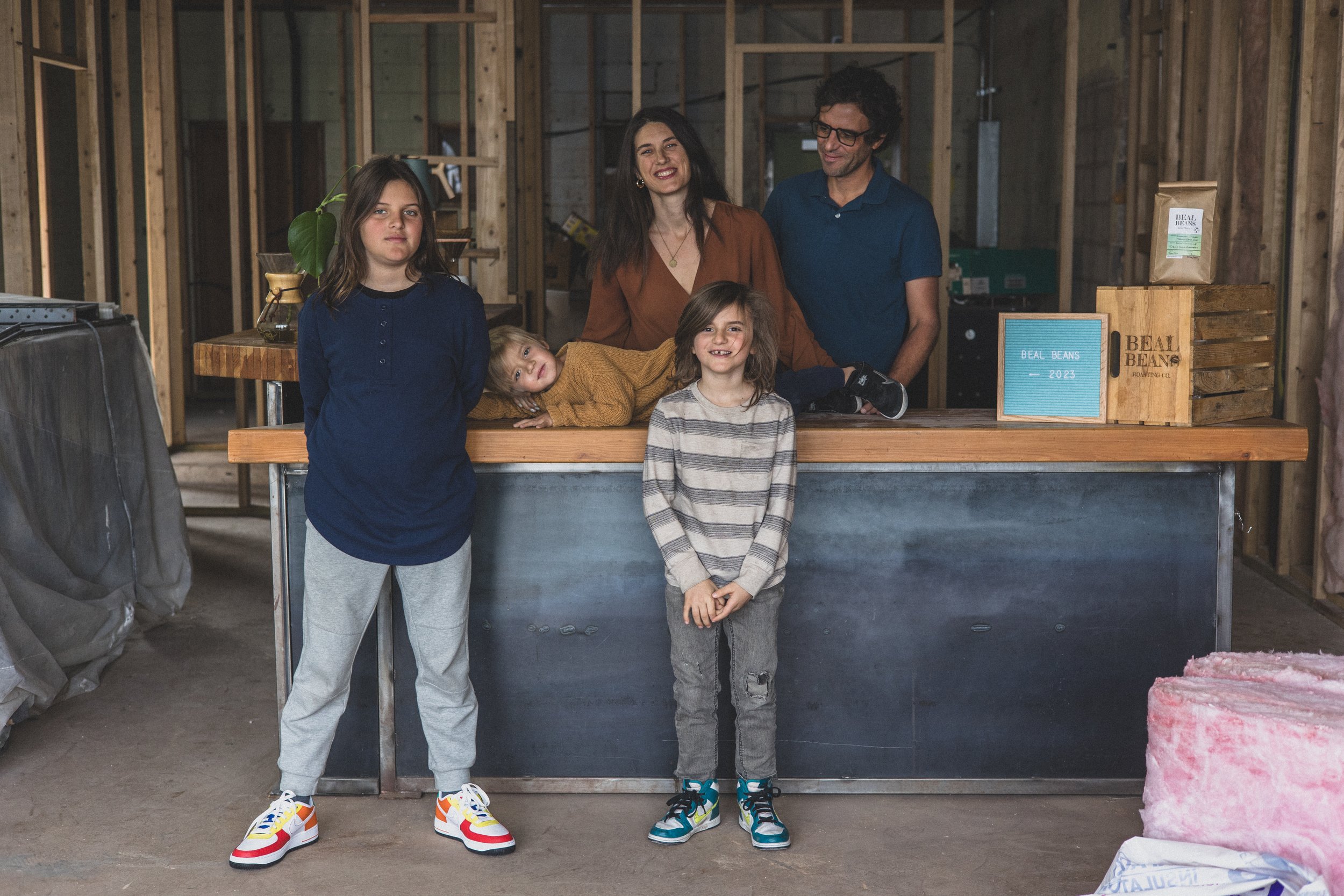 Family poses for their unique photo session in the unfinished Beal Beans’ new coffee shop coming to Sunnyslope, AZ by Arizona family photographer, Jennifer Lind Schutsky. 