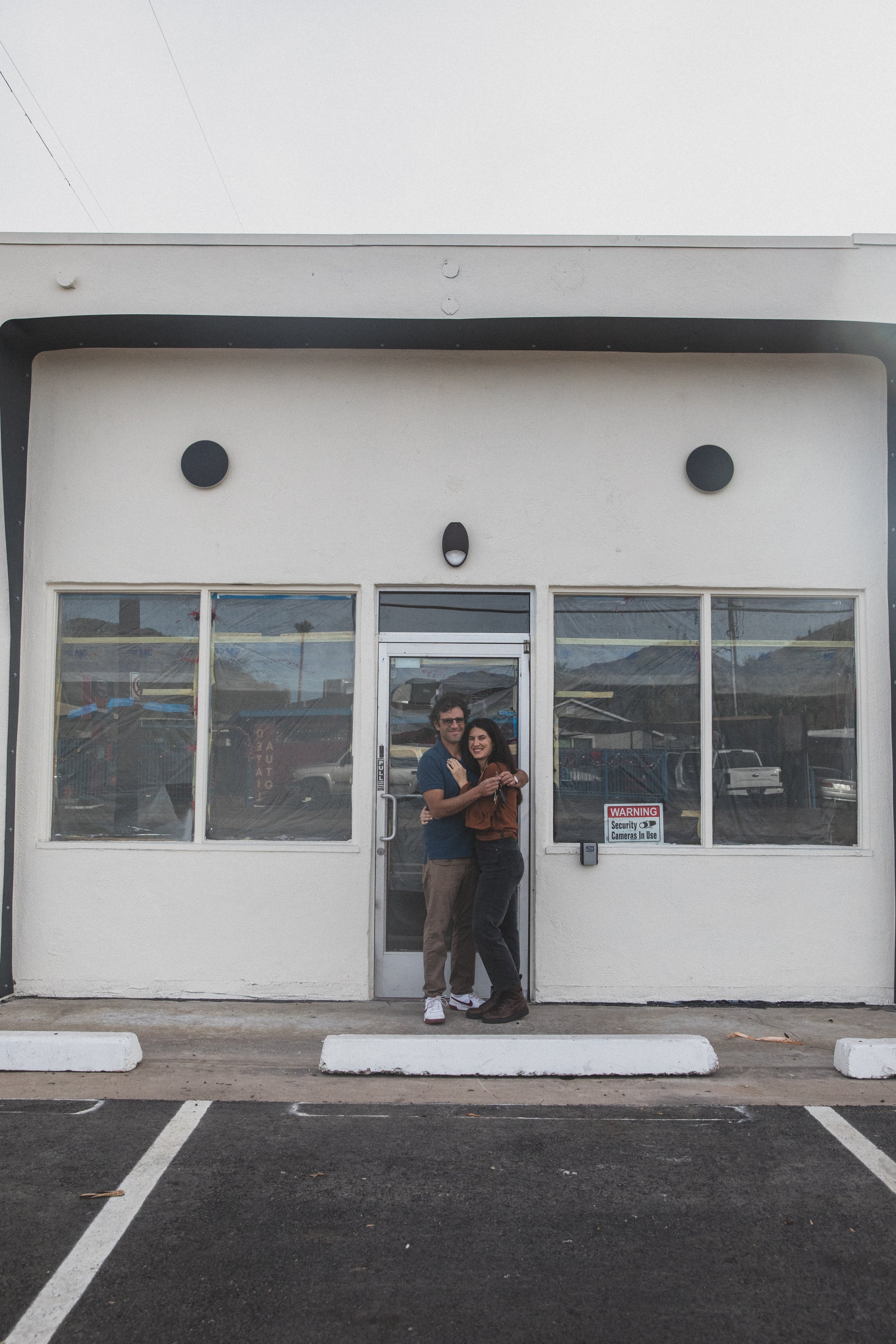 Couple poses in front of the Beal Beans’ new coffee shop coming to Sunnyslope, AZ by best Phoenix family photographer, Jennifer Lind Schutsky. 