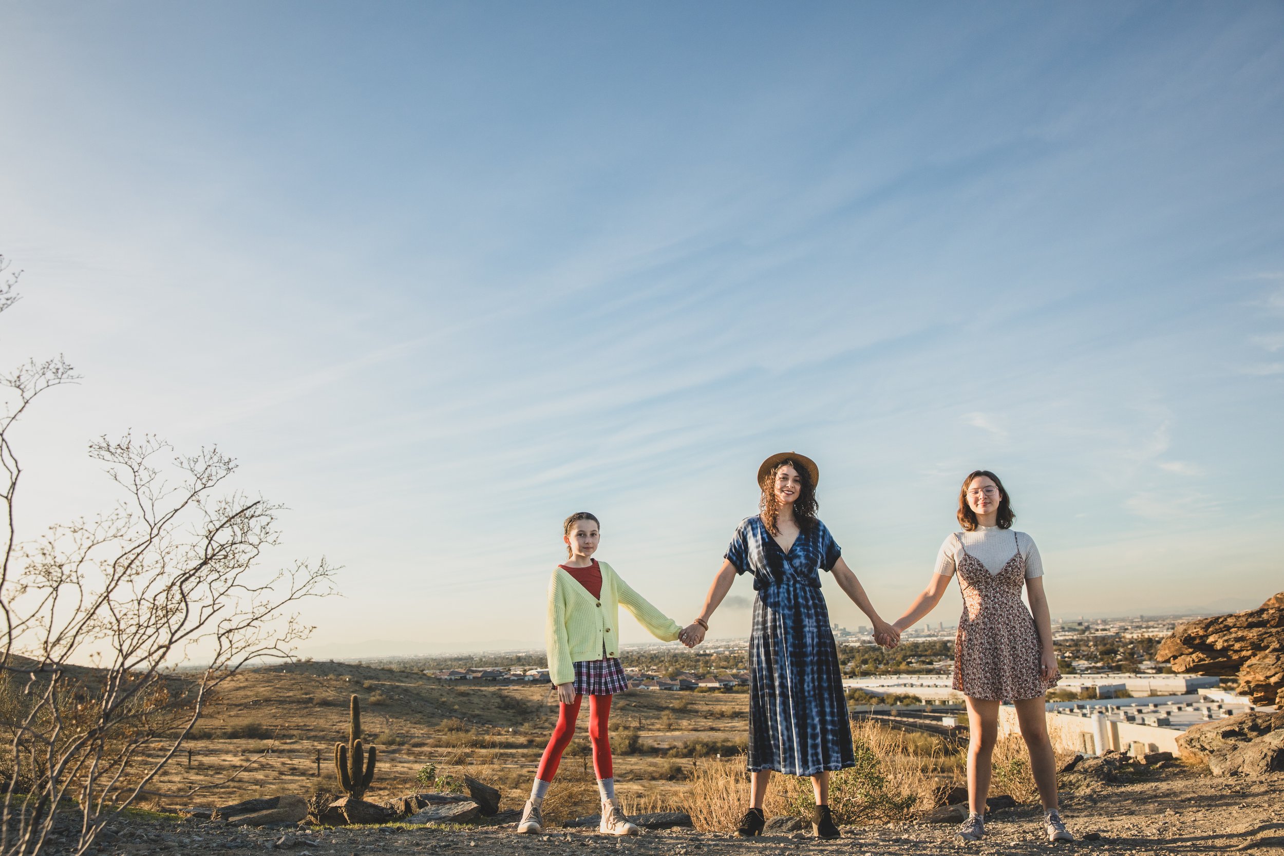 Woman and children pose on top of mountain boulders during their creative, lifestyle, desert family photography session with Phoenix photographer, Jennifer Lind Schutsky.