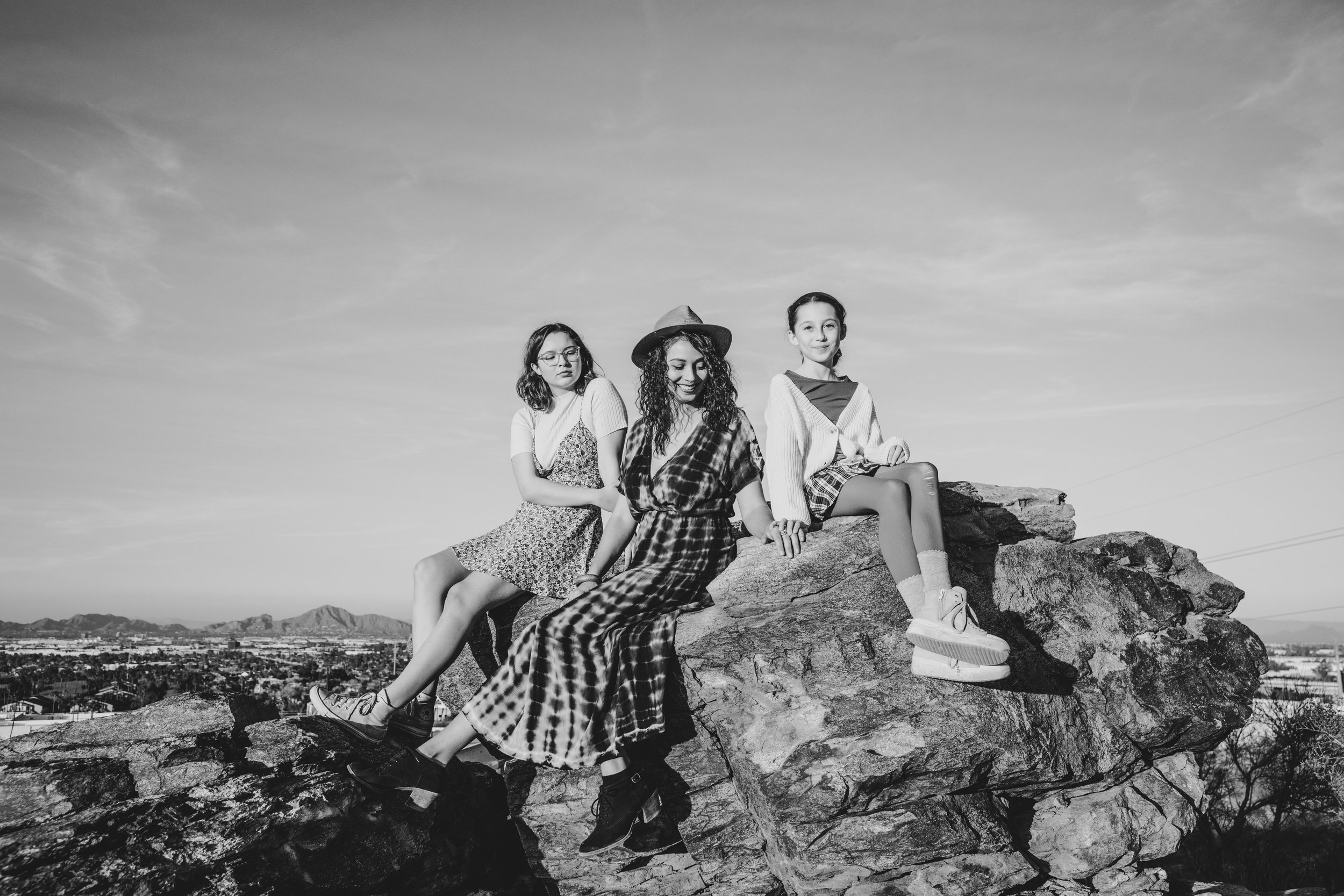 Woman and children pose on top of mountain rocks during their desert family photography session with Phoenix photographer, Jennifer Lind Schutsky.