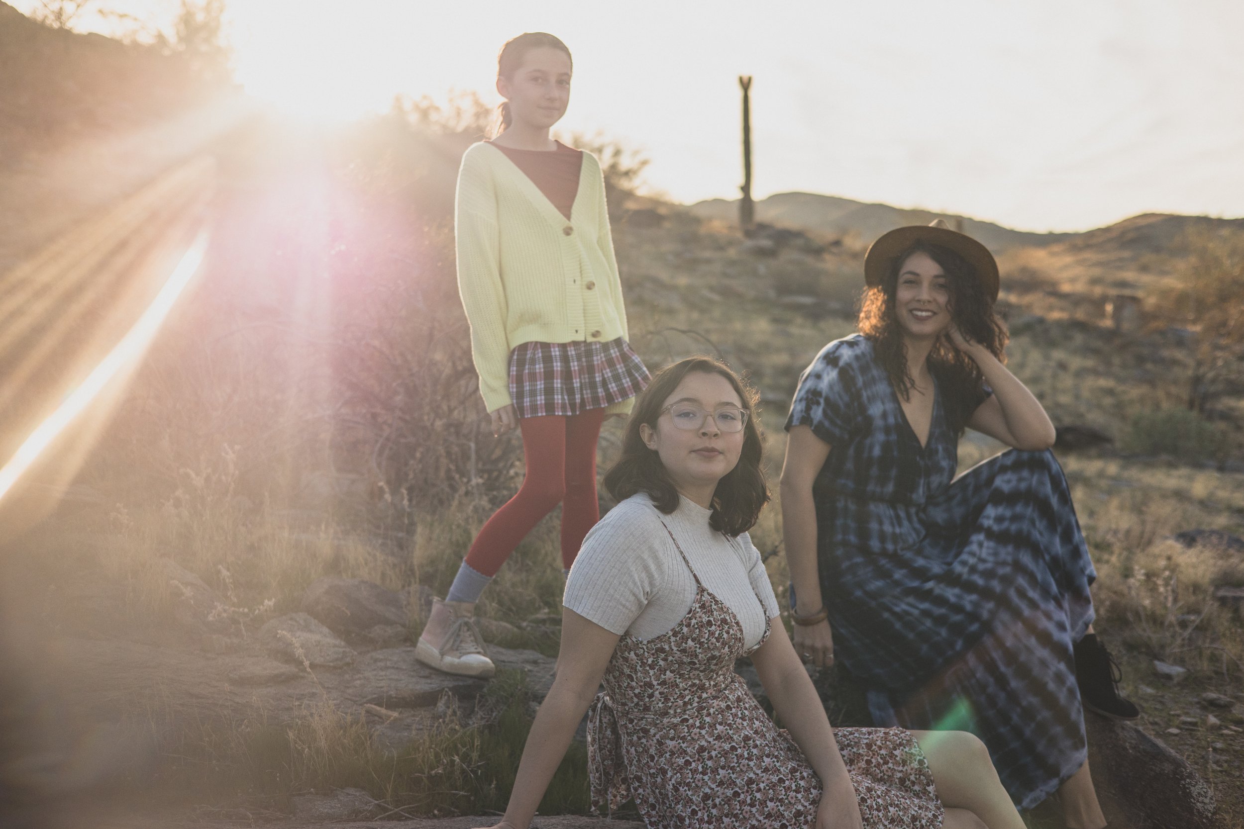 Woman and children pose on top of mountain boulders during their desert family photography session with Phoenix photographer, Jennifer Lind Schutsky.