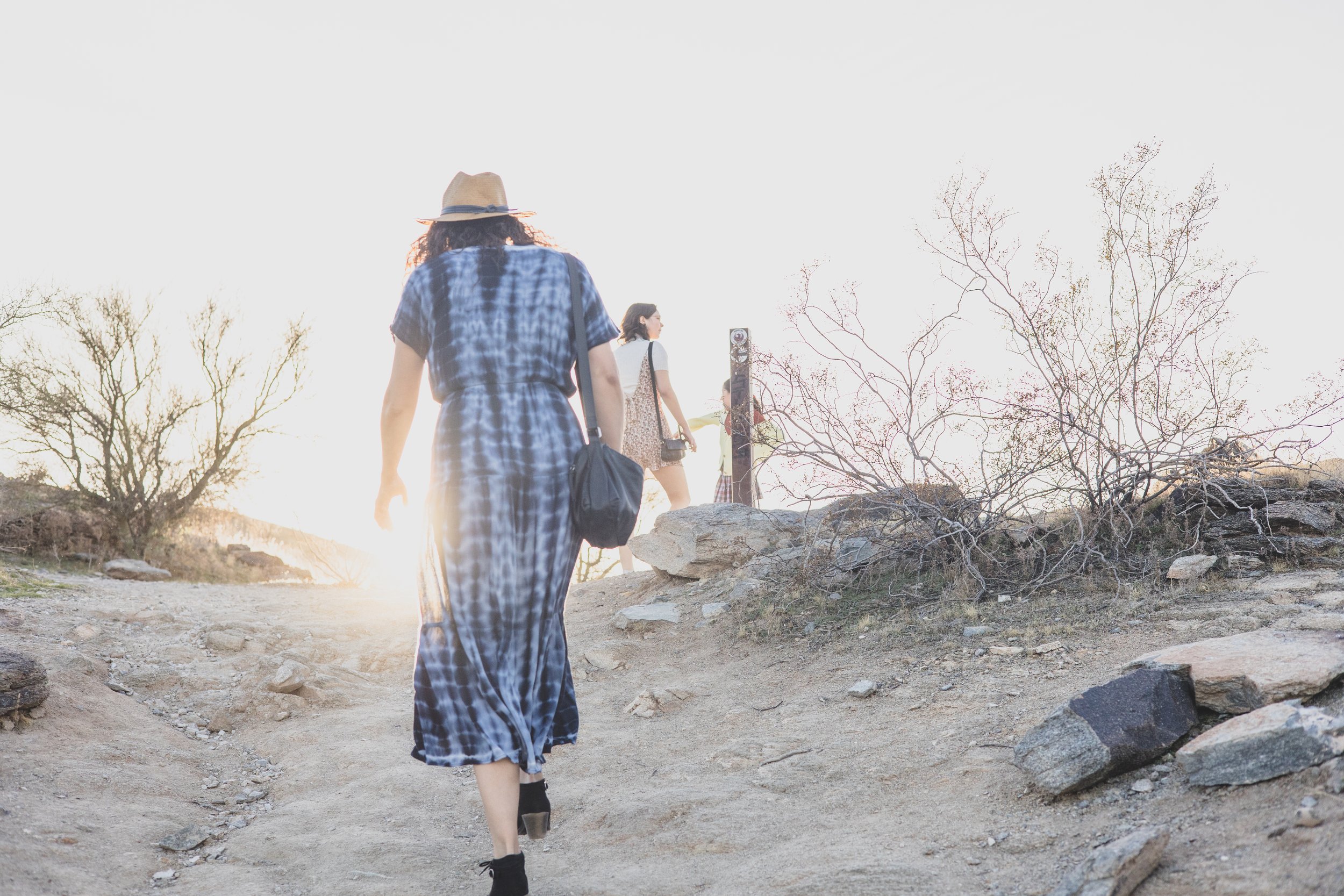 Woman in blue dress and children walking up mountain during their desert family photography session with Phoenix photographer, Jennifer Lind Schutsky.