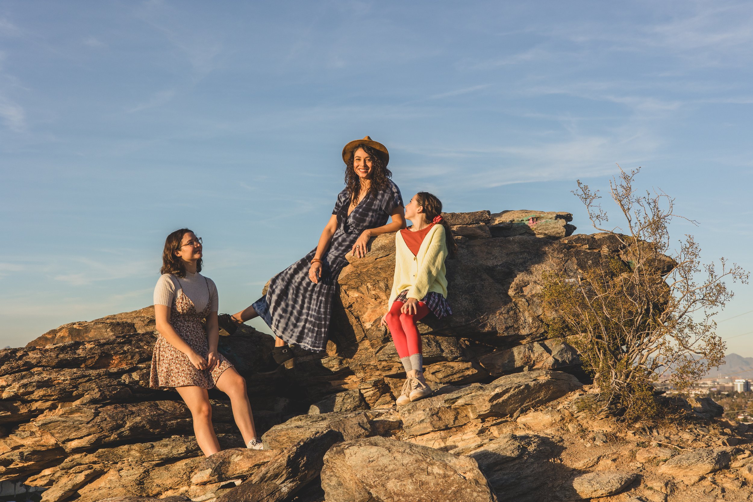 Woman and children pose on top of mountain boulders during their creative desert family photography session with Phoenix photographer, Jennifer Lind Schutsky.