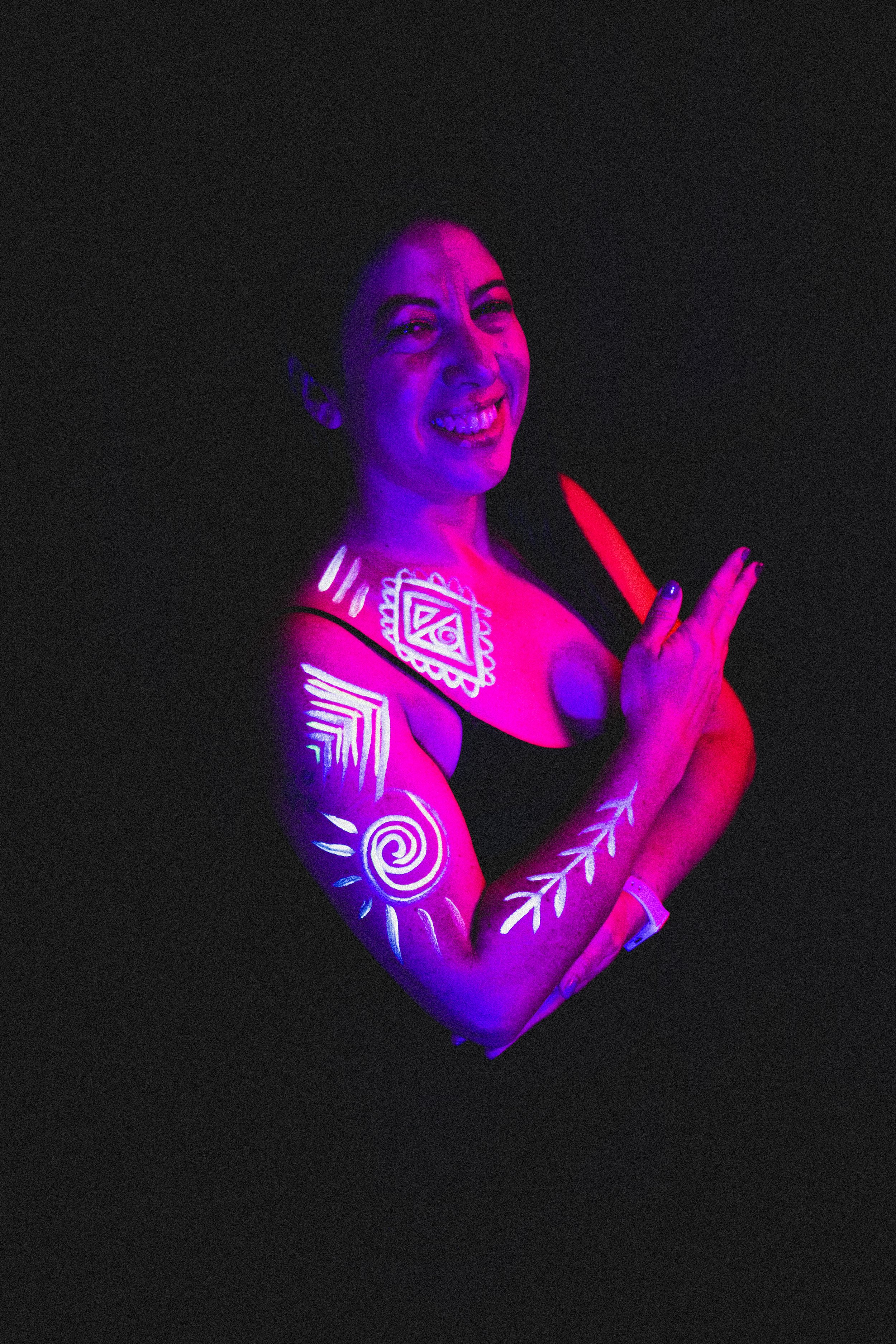 Woman poses with geometric neon body paint on her arm for alternative neon body painting creative photoshoot by phoenix body artist, La Luna Henna and photographer Jennifer Lind Schutsky.