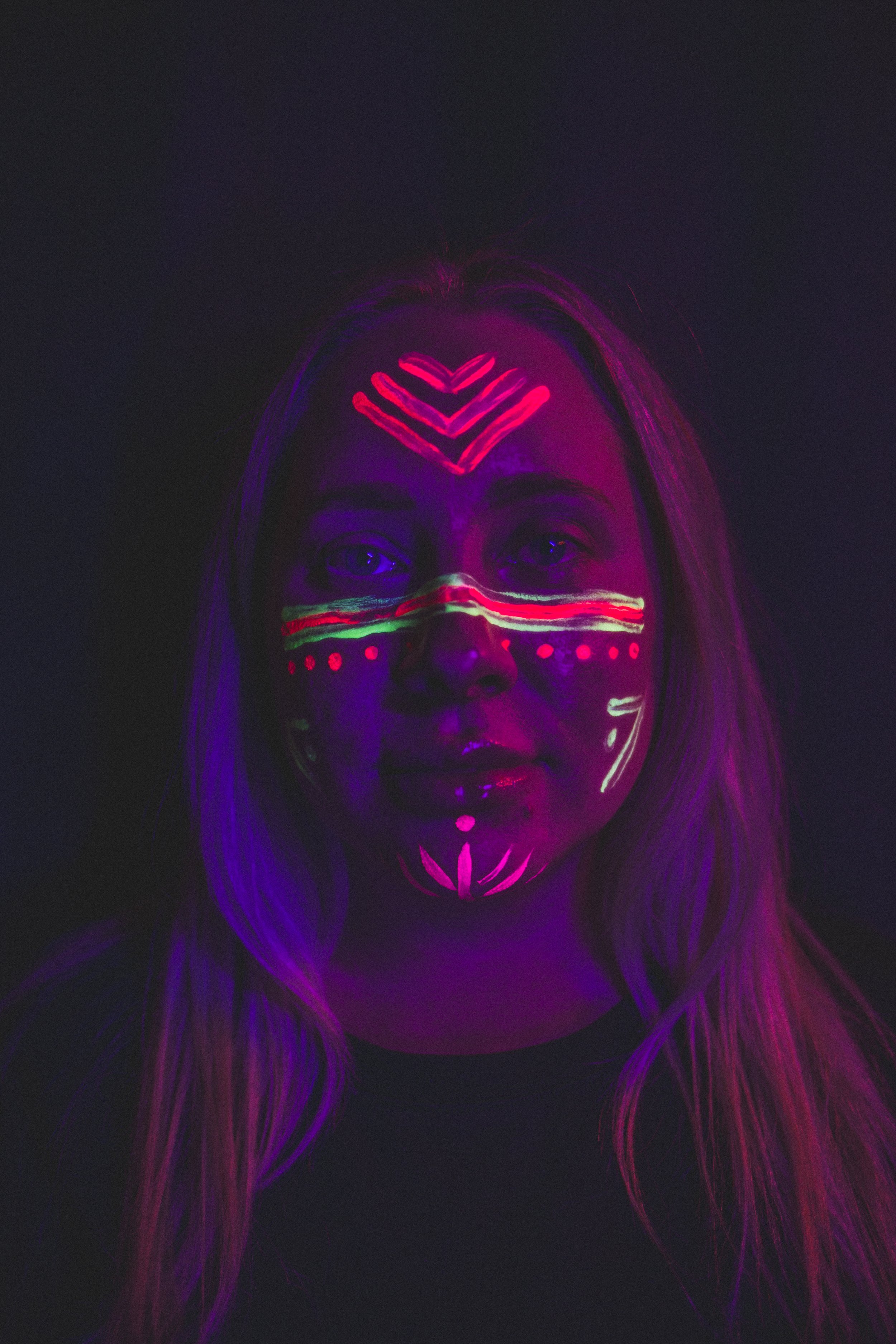 Woman poses with trendy neon body paint on their face for alternative neon body painting creative photoshoot by phoenix body artist, La Luna Henna and photographer Jennifer Lind Schutsky.