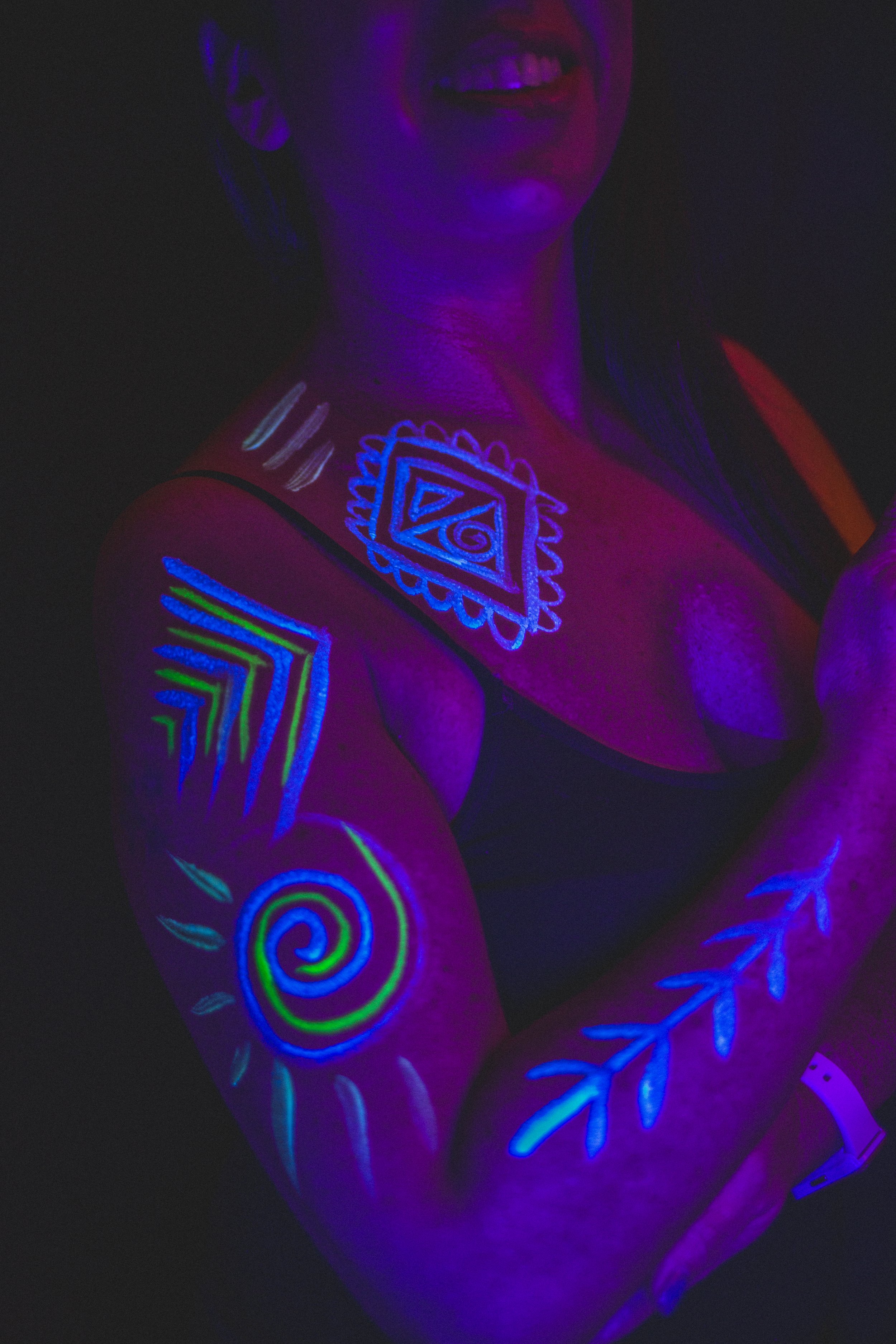 Woman poses with geometric neon body paint on her arm and chest for alternative neon body painting creative photoshoot by phoenix body artist, La Luna Henna and photographer Jennifer Lind Schutsky.