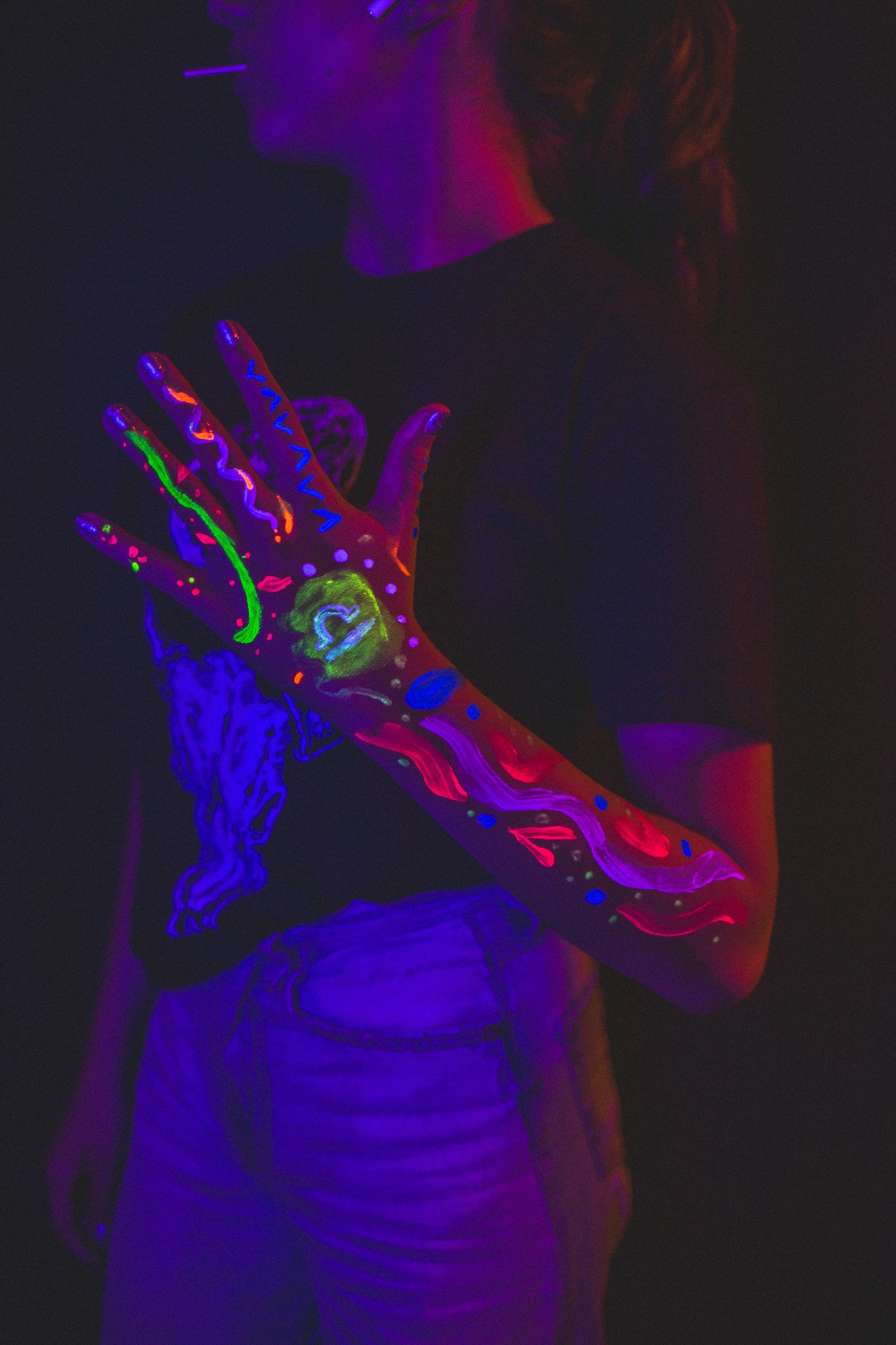 Kid poses with geometric neon body paint on their arm for alternative neon body painting creative photoshoot by phoenix body artist assistant of La Luna Henna and photographer Jennifer Lind Schutsky.