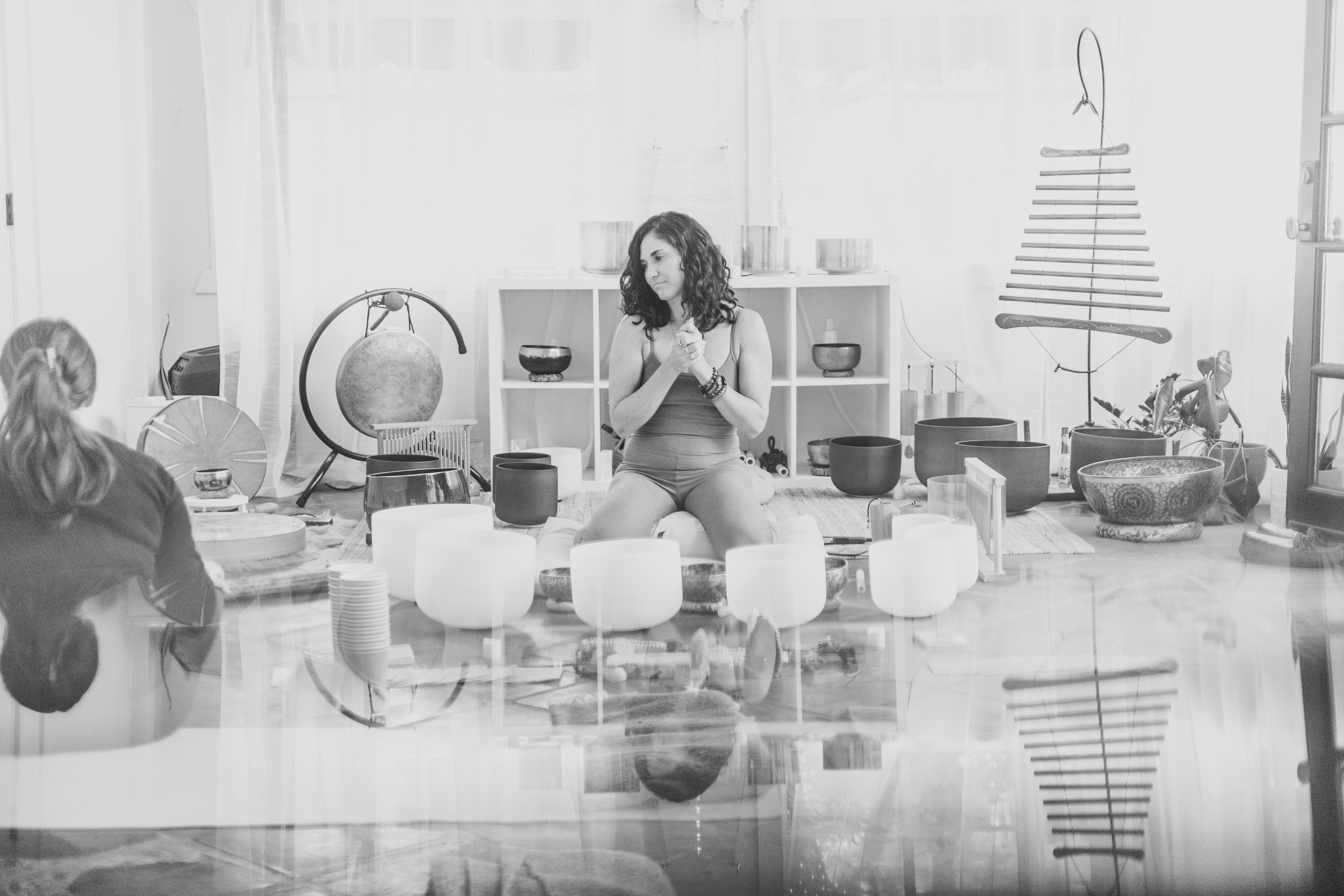 Woman poses with crystal sound bowls at documentary style branding photo session in Scottsdale, with best Arizona branding photographer, Jennifer Lind Schutsky.