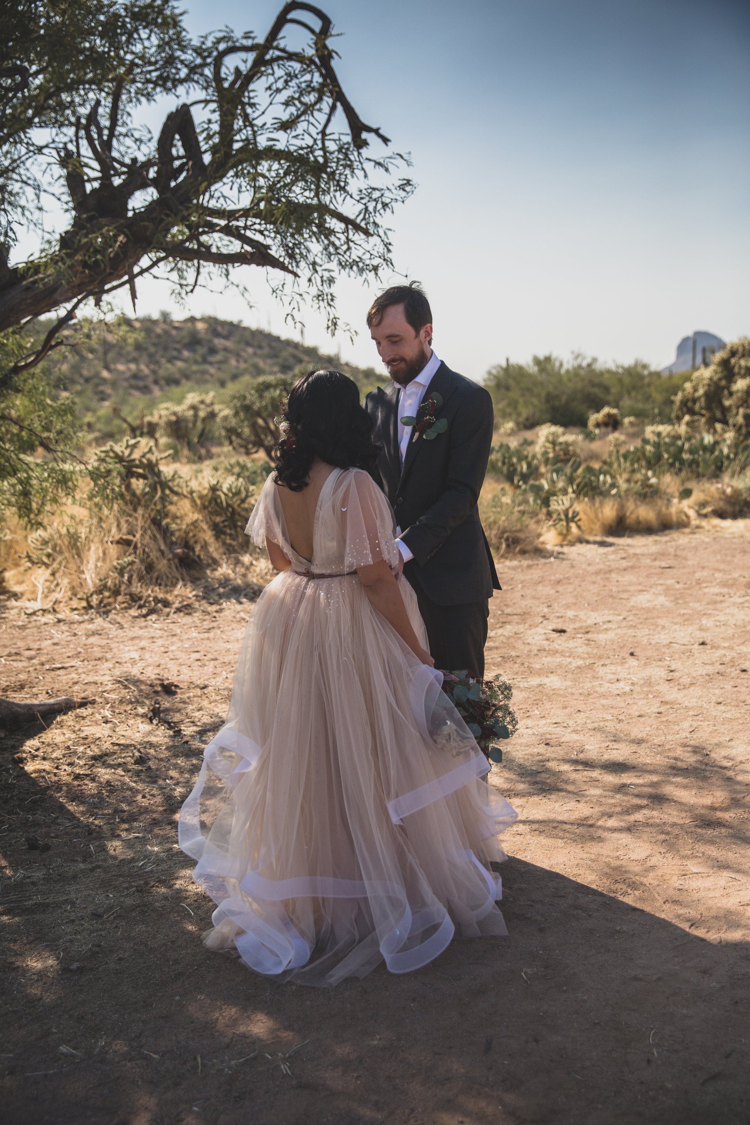 Bride and Groom gazing into each other’s eyes during their first look at their intimate Superstition Mountain micro wedding in Arizona by experienced wedding photographer, Jennifer Lind Schutsky. 