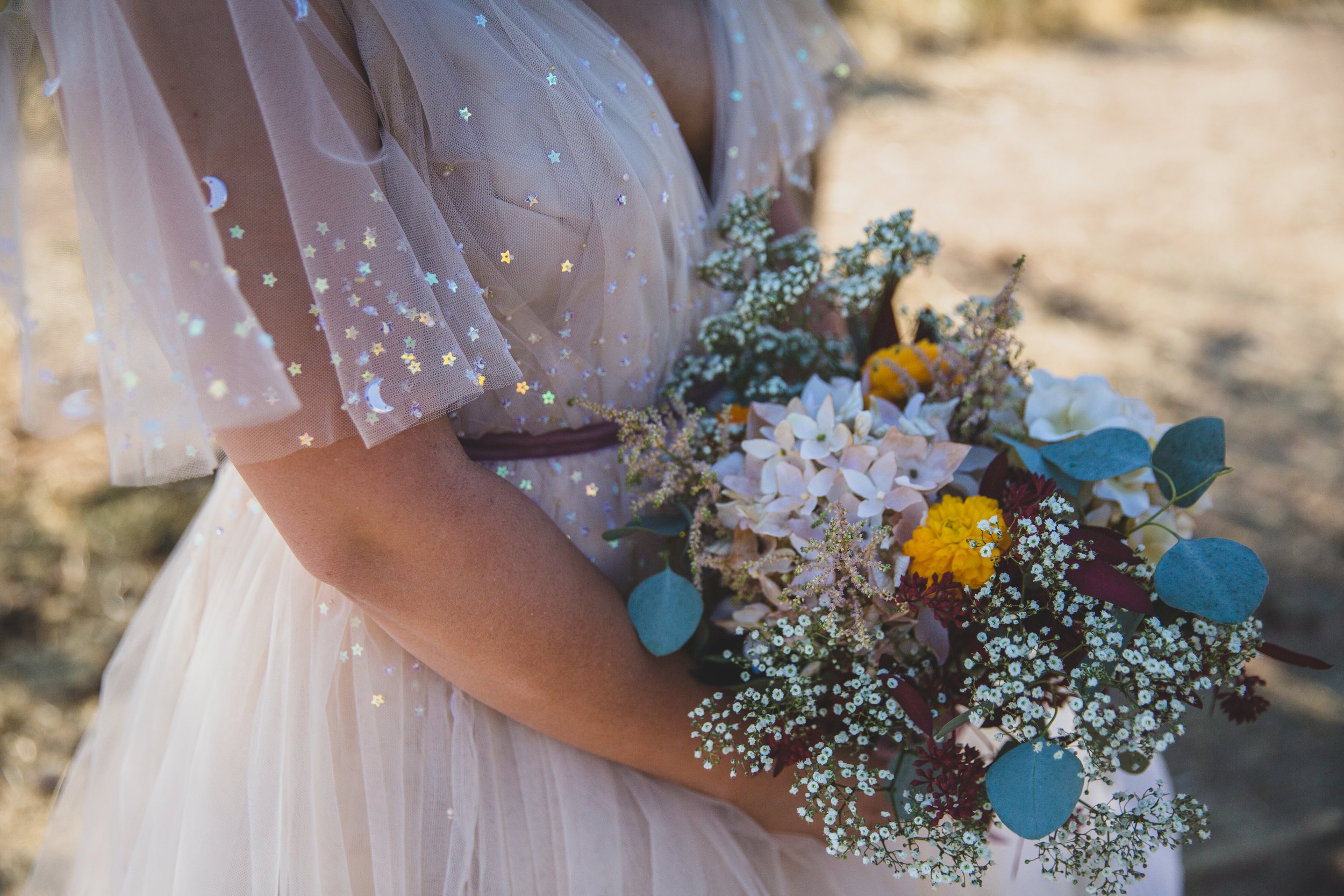 Bride and her wildflower floral bouquet detail for Superstition Mountain intimate wedding near Phoenix, Arizona by wilderness wedding photographer, Jennifer Lind Schutsky. 