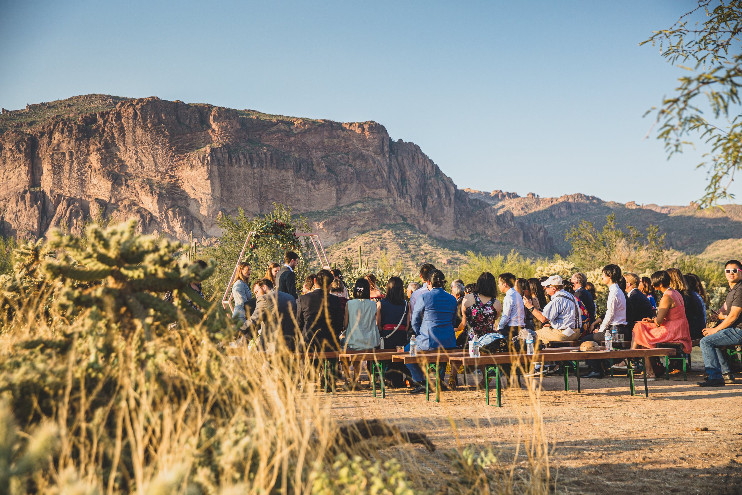 Guests watching the wedding ceremony at an intimate Superstition Mountain micro wedding in  rural Arizona by destination wedding photographer, Jennifer Lind Schutsky. 