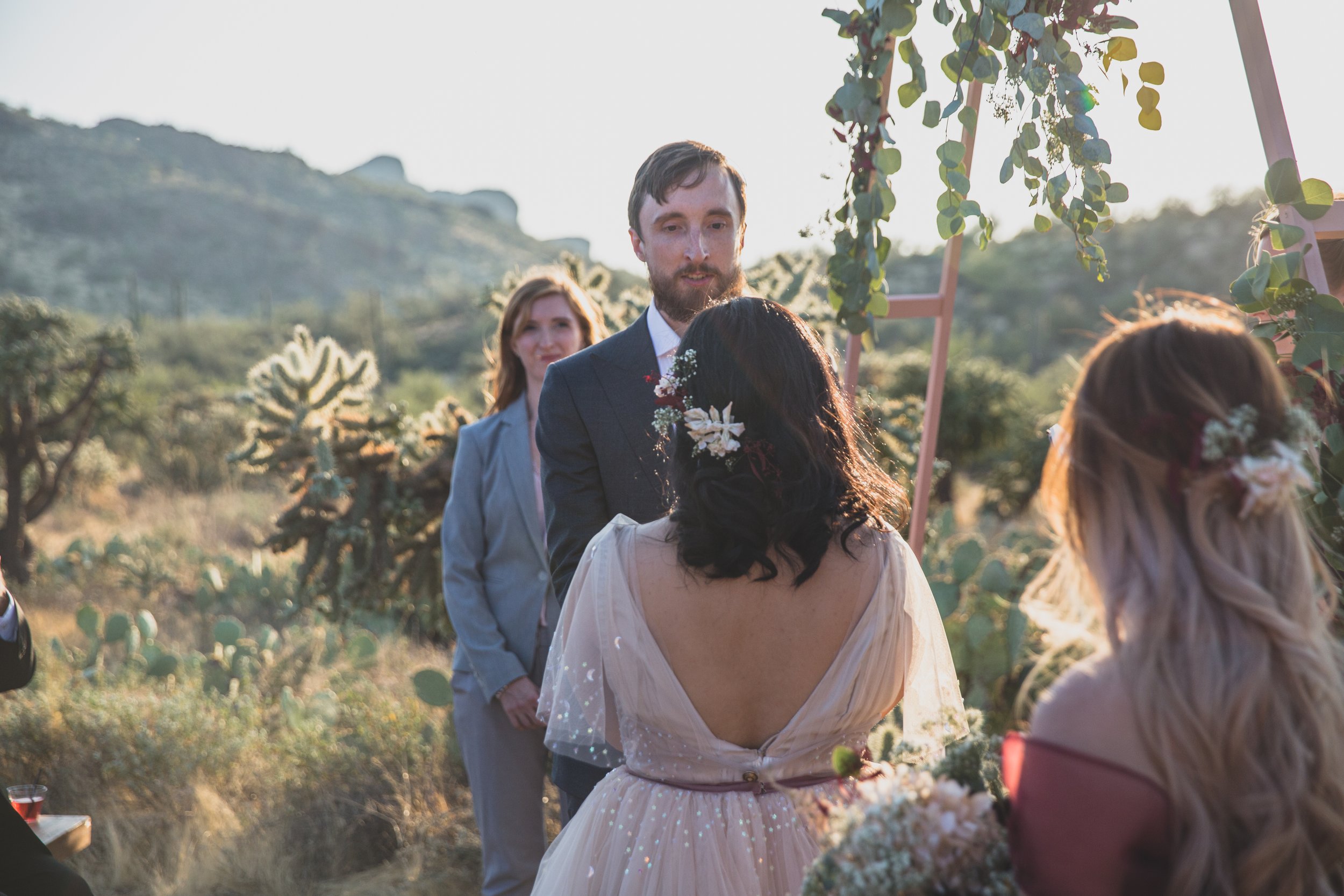 Bride and groom share their vows at their wedding ceremony at an intimate Superstition Mountain micro wedding in rural Arizona by destination wedding photographer, Jennifer Lind Schutsky. 