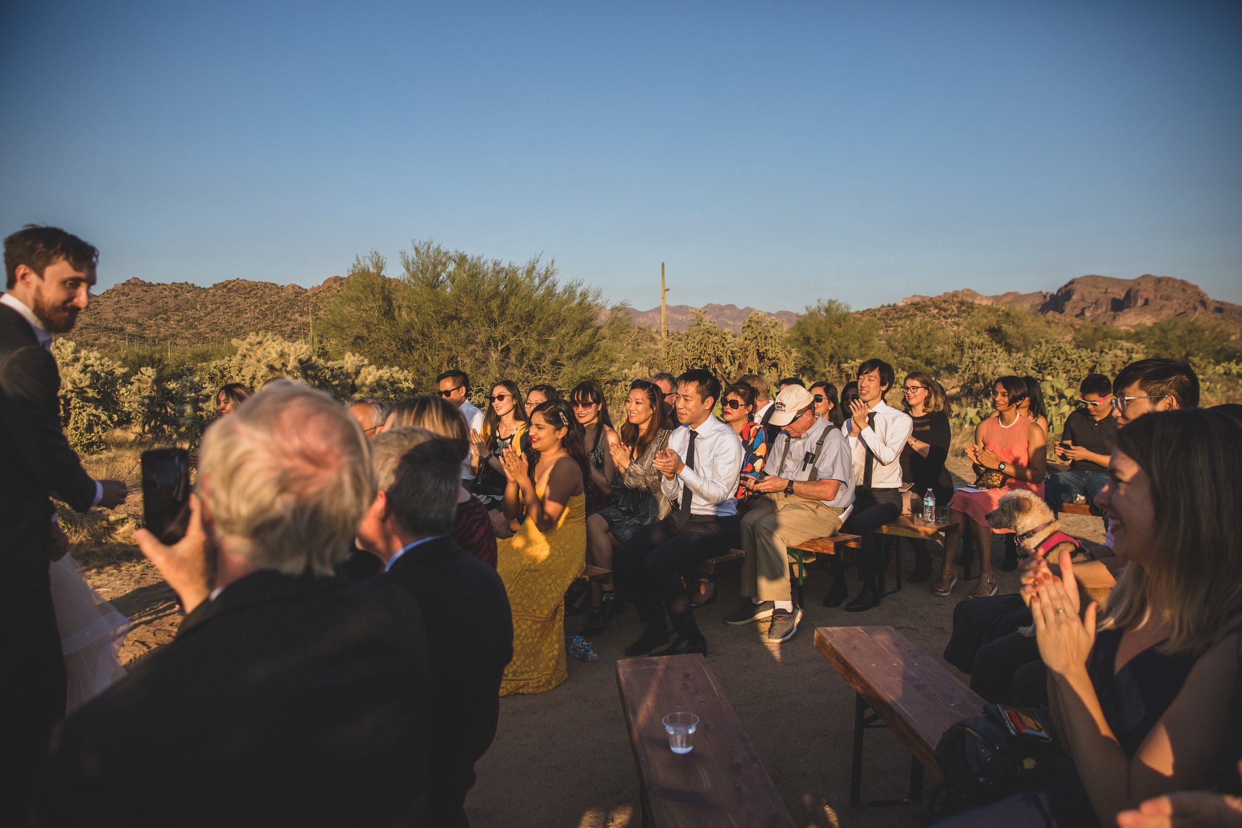 Guests watching the wedding ceremony at an intimate Superstition Mountain micro wedding in  rural Arizona by destination wedding photographer, Jennifer Lind Schutsky. 