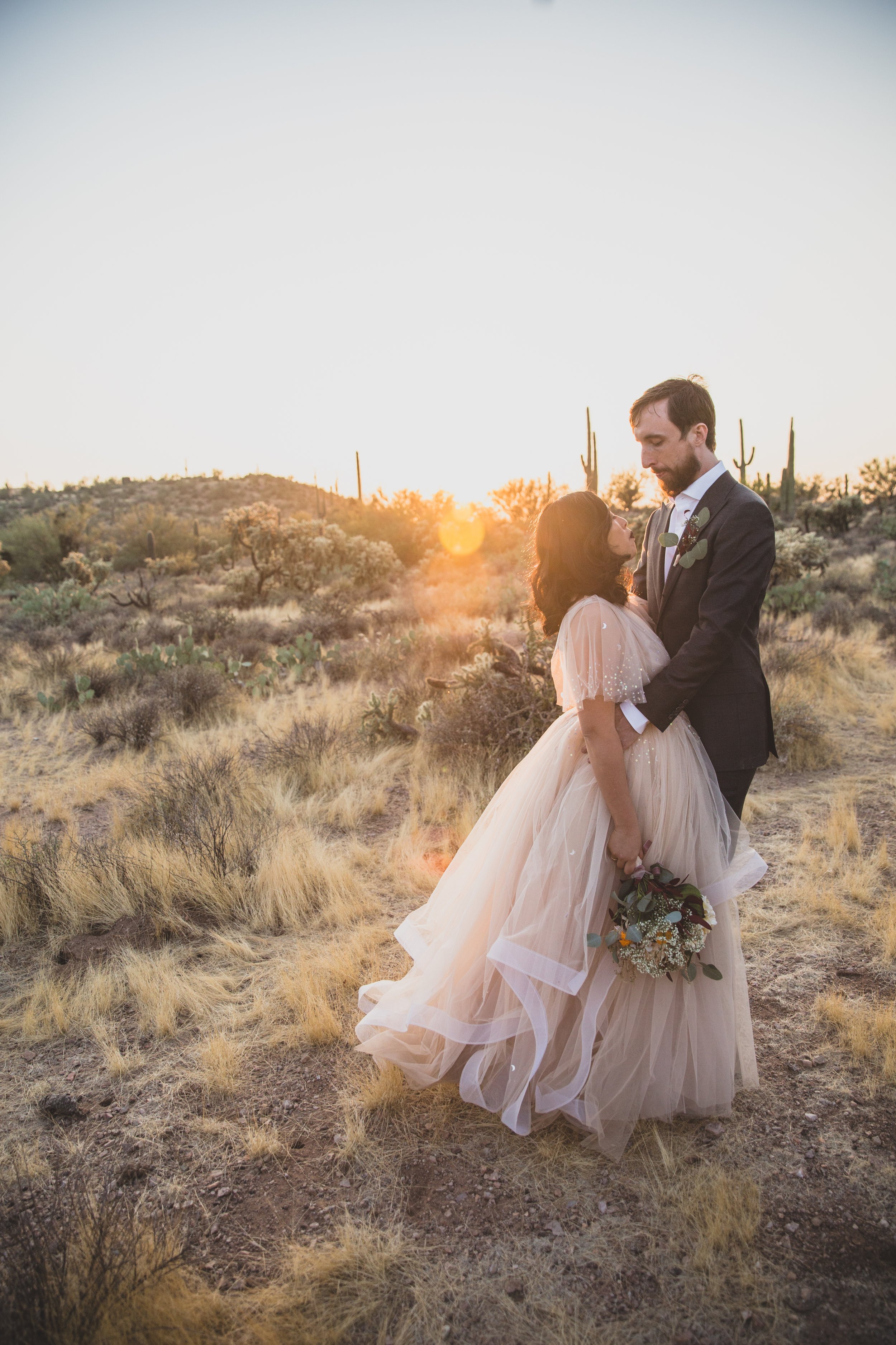 Couple poses for at their intimate Superstition Mountain micro wedding in  rural Arizona by destination wedding photographer, Jennifer Lind Schutsky. 