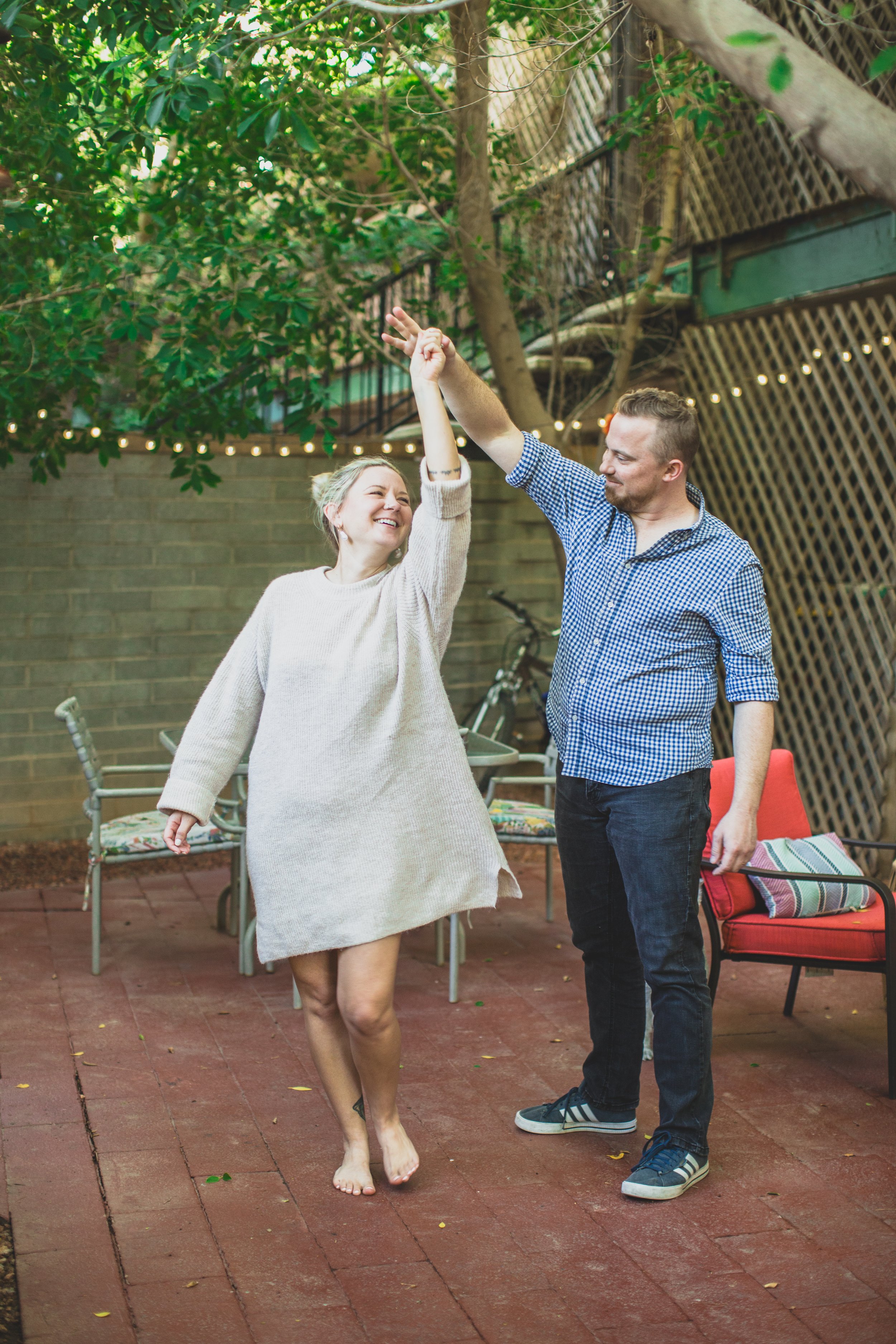 Couple dances on their patio during their in-home engagement photo session with Phoenix based creative wedding photographer; Jennifer Lind Schutsky. 