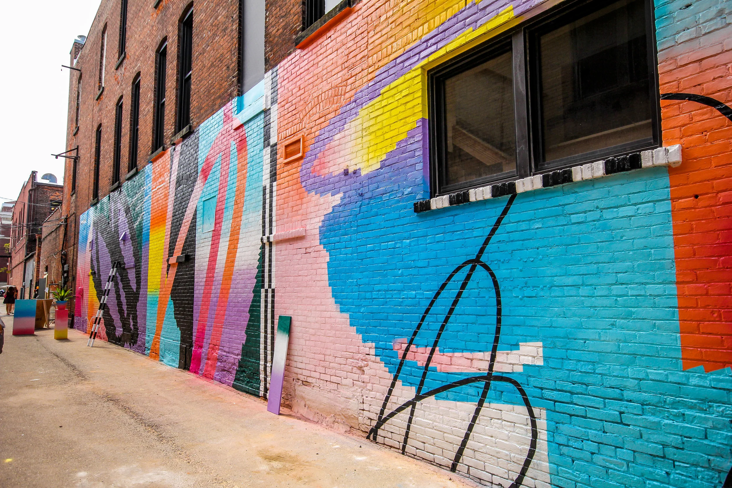 A vibrant street mural on a brick wall with abstract shapes and bold colors