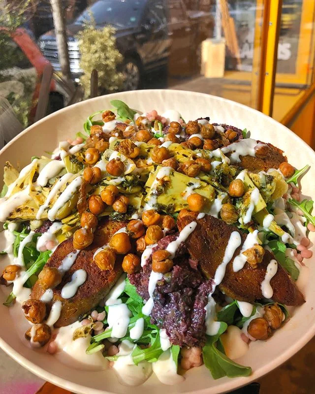 Forever dreaming about our Dream On! bowl 💭🥗😍 filled with house-made seitan based spicy merguez sausage, artichoke hearts, pink couscous, fresh peppery arugula, a dollop of olive tapenade, and house-made lemon garlic aioli 🍋