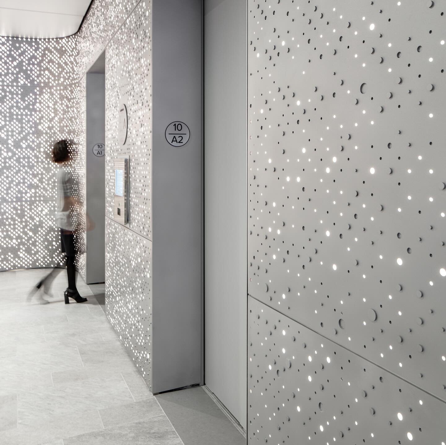 For this financial service firm, it's all in the details! Stepping off the elevator, a dazzling, illuminated lobby crafted from bespoke three-dimensional perforated aluminum panels welcomes visitors. Subtle signage directs them to an open welcome are