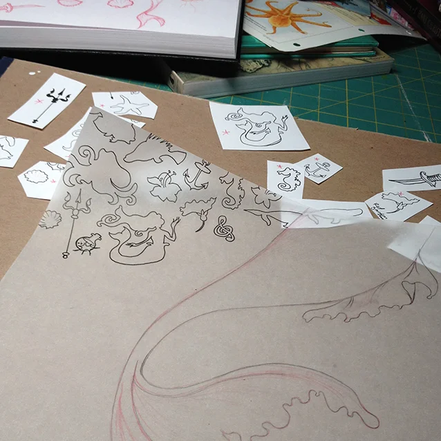 once i decided on the icon shapes i wanted to use in the background pattern, i start tracing them to fill in the background around the mermaid’s tail.