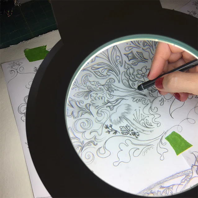 my trusty magnifying lamp, trying to help me not go blind for details as i re-trace my drawing down to the watercolour paper.