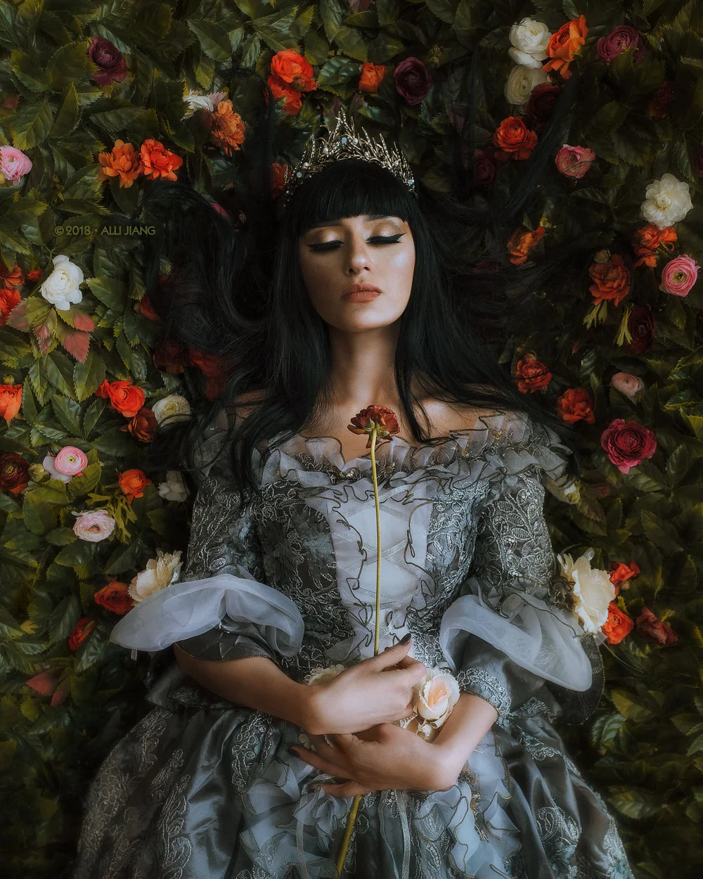 Renaissance-inspired portrait in a blue period gown surrounded by painted florals